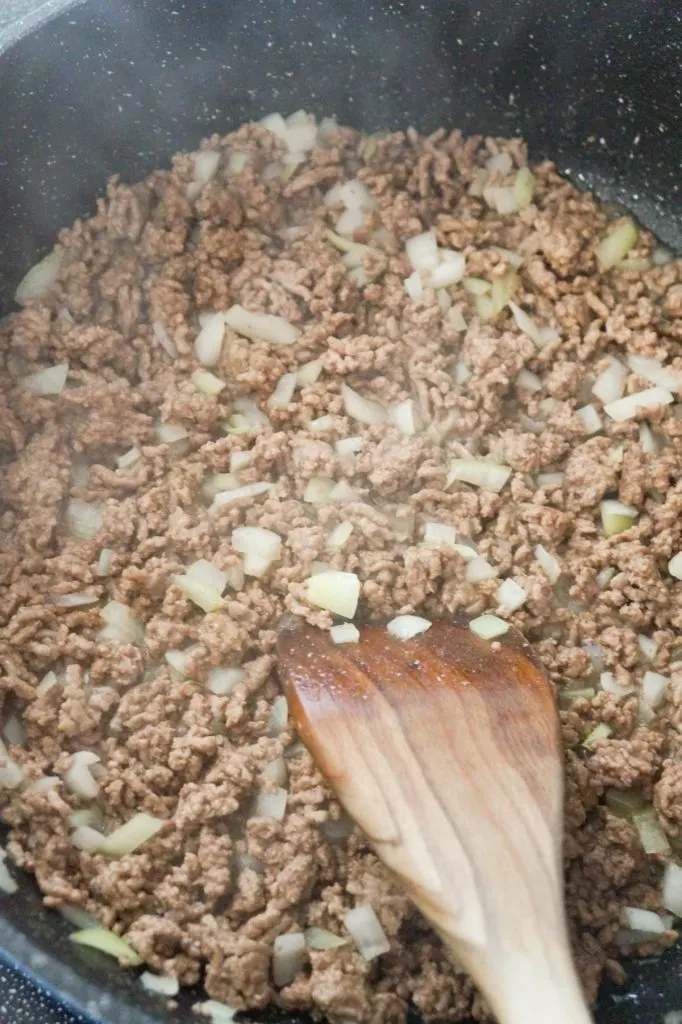 cooked ground beef and diced onions in a saute pan