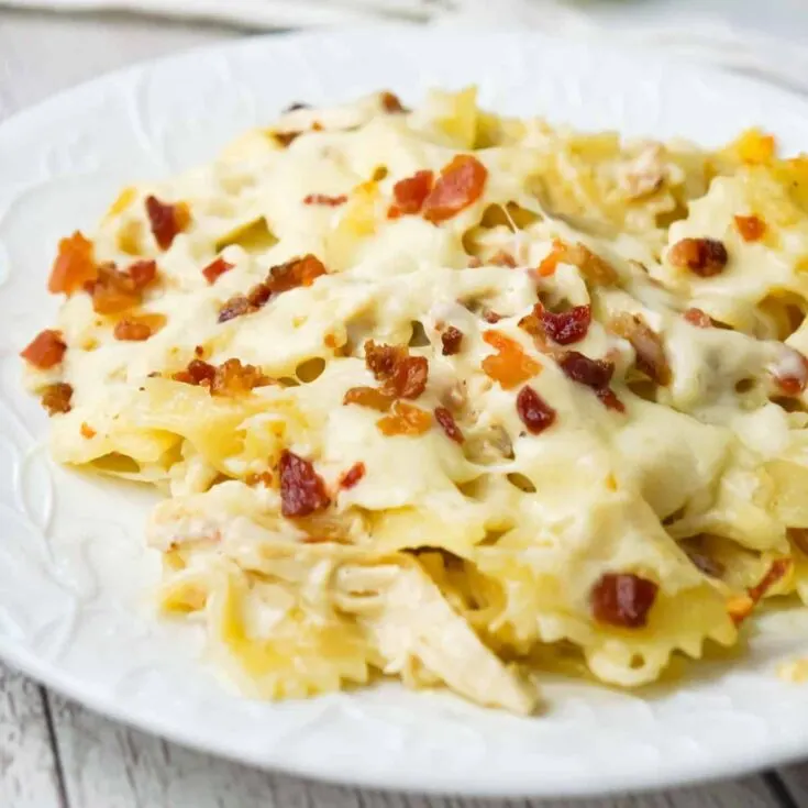 Baked Chicken Alfredo Pasta with Bacon is a delicious dinner recipe loaded with bow tie pasta, shredded chicken and crumbled bacon all in a creamy garlic Parmesan sauce and baked with mozzarella on top.