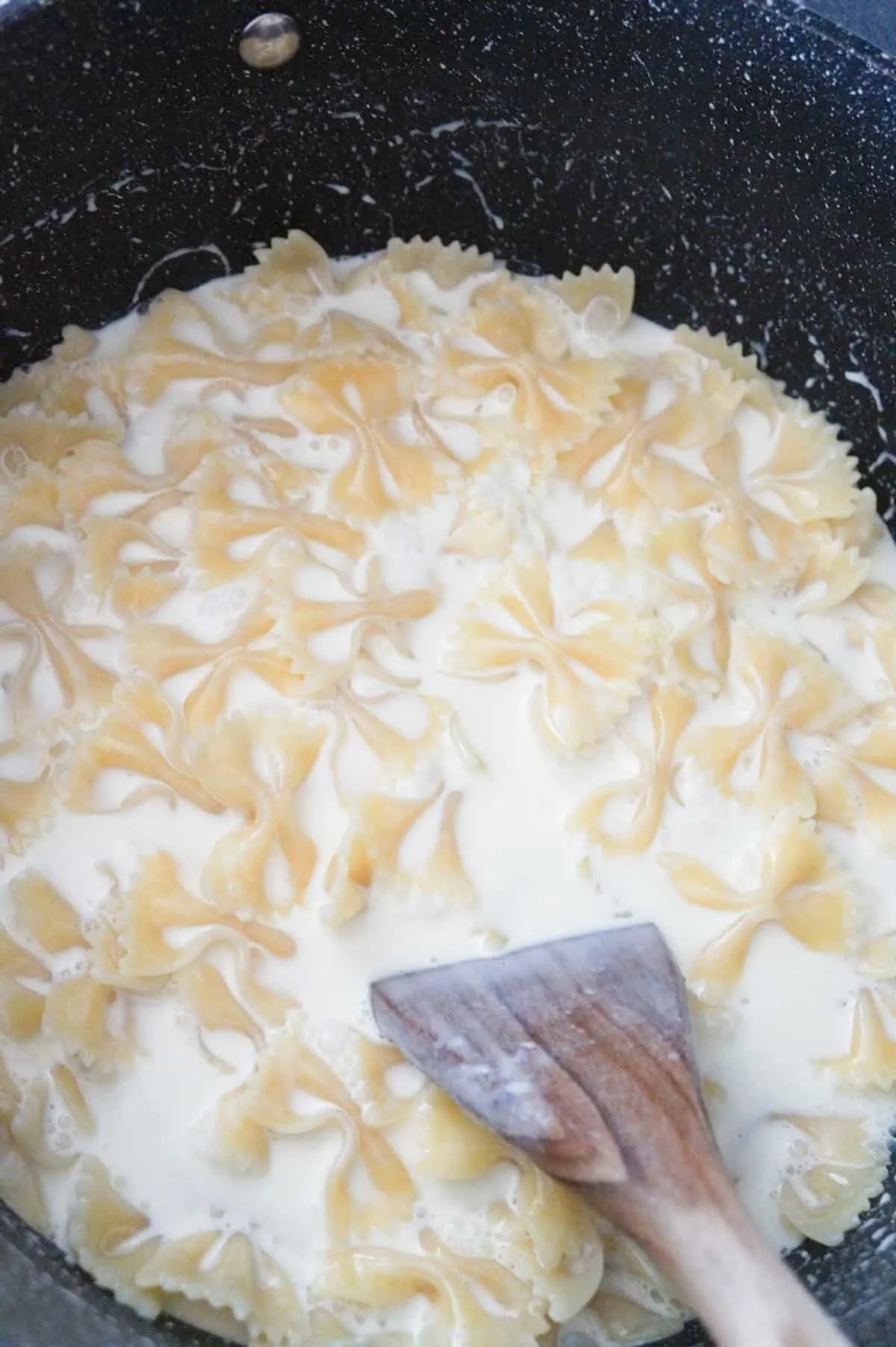 heavy cream and bow tie pasta in a large pot