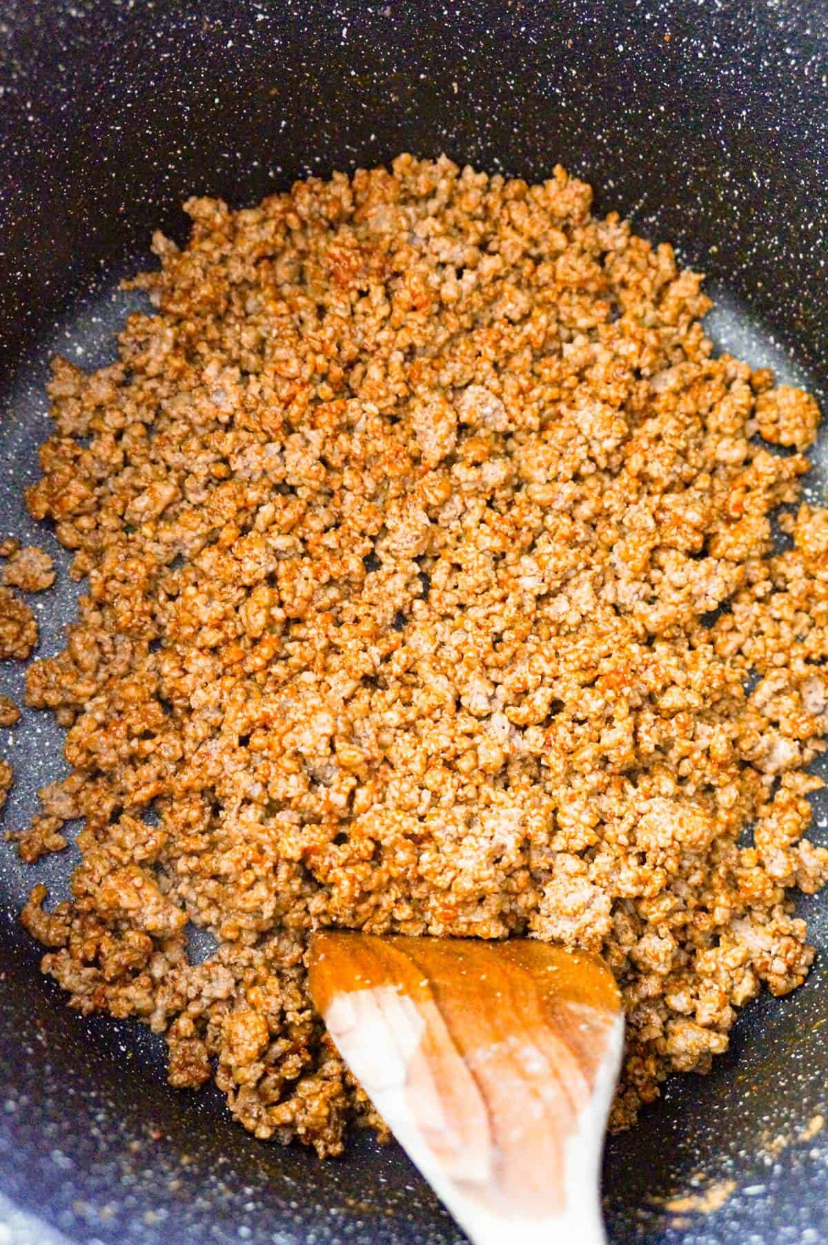 ground beef coated in chili seasoning in a large pot