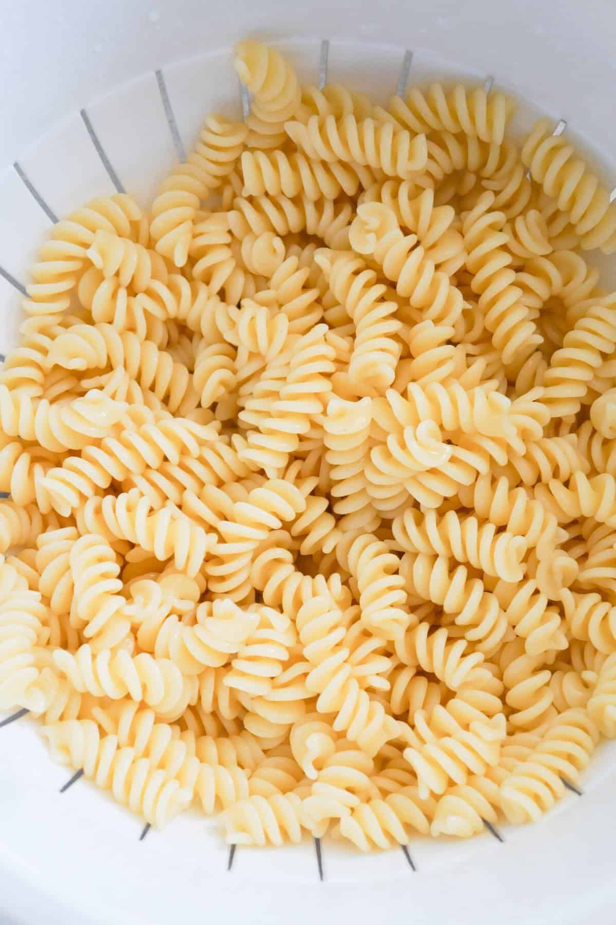 cooked fusilli noodles in a strainer