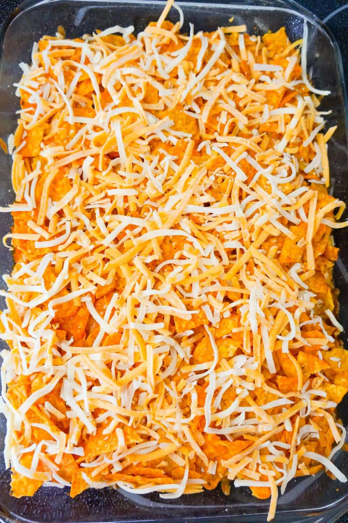 shredded cheese on top of Doritos chili pie