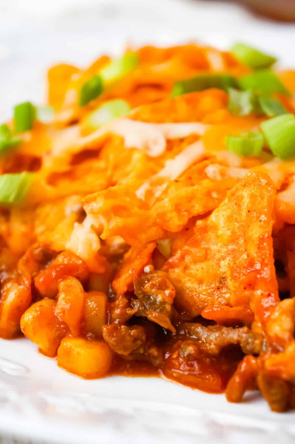 Doritos Chili Pie is an easy ground beef casserole recipe loaded with chili sauce, chunky salsa, corn, shredded cheese, crumbled Doritos and chopped green onions.