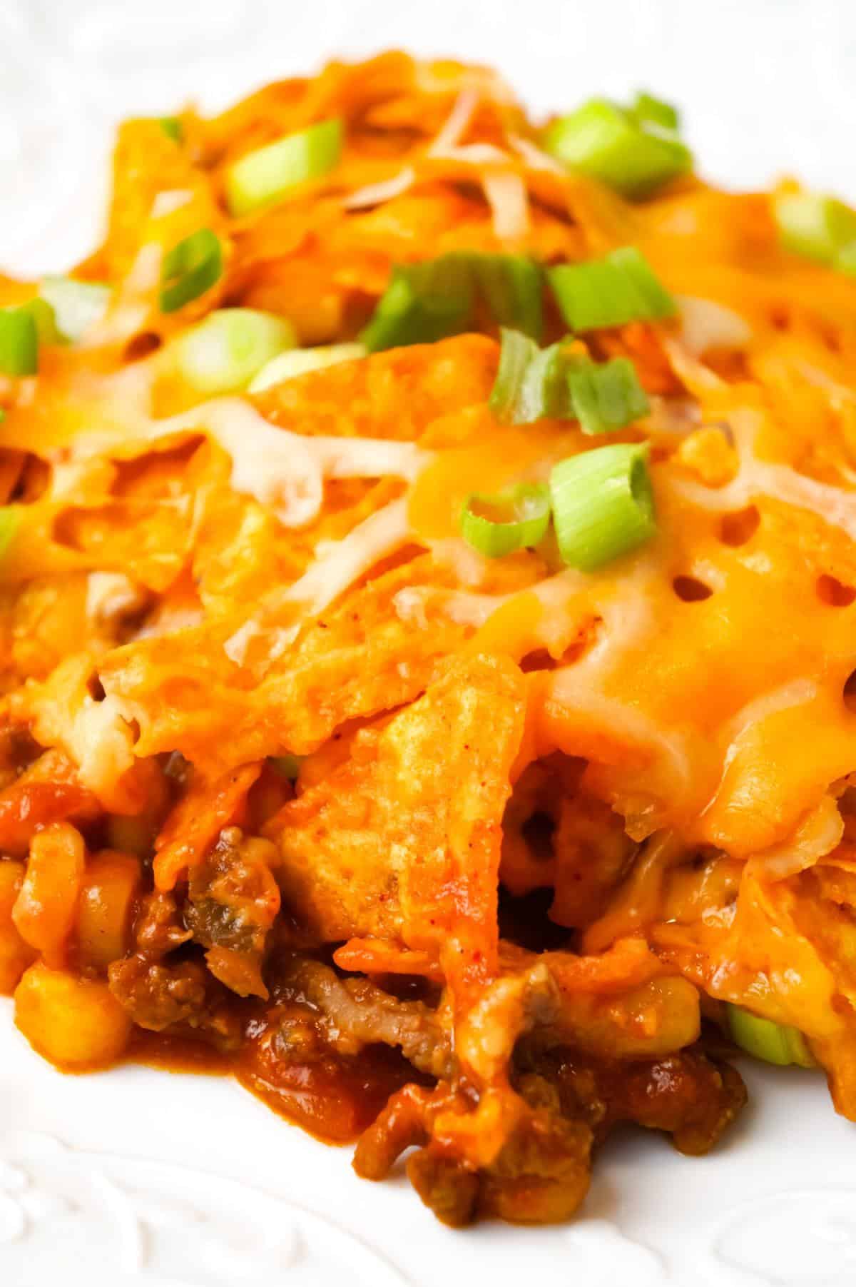 Doritos Chili Pie is an easy ground beef casserole recipe loaded with chili sauce, chunky salsa, corn, shredded cheese, crumbled Doritos and chopped green onions.