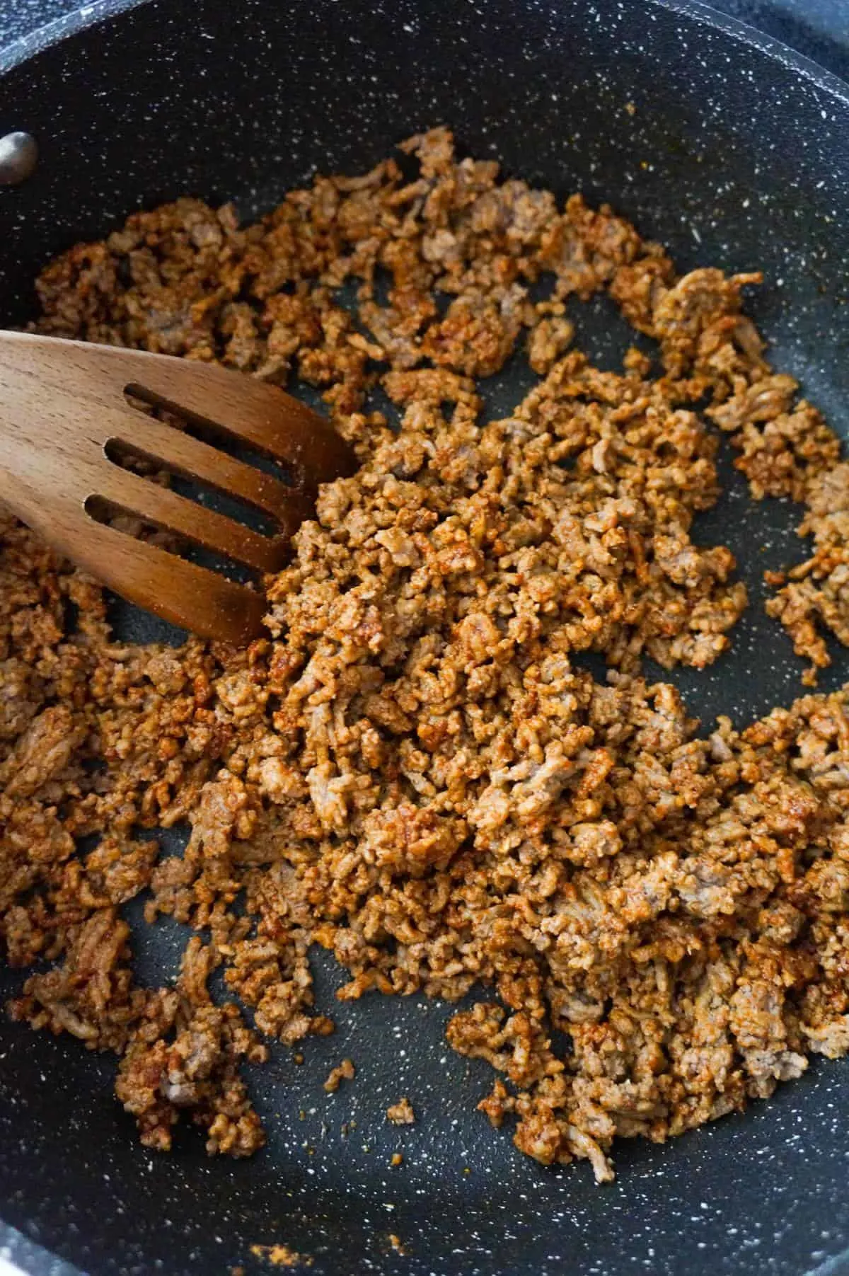 cooked ground beef coated in chili seasoning in a saute pan