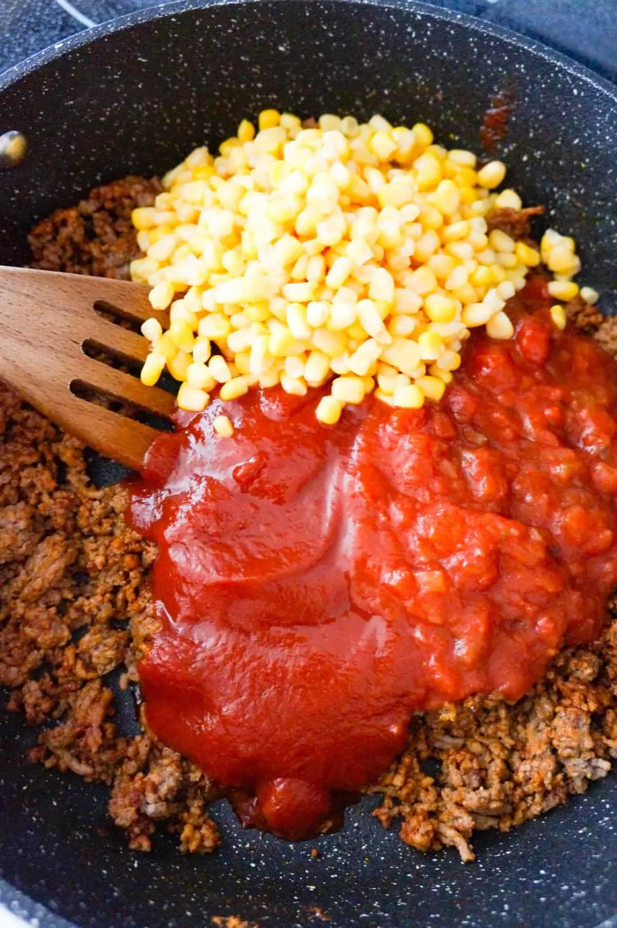 corn, Heinz chili sauce and chunky salsa on top of cooked ground beef in a saute pan