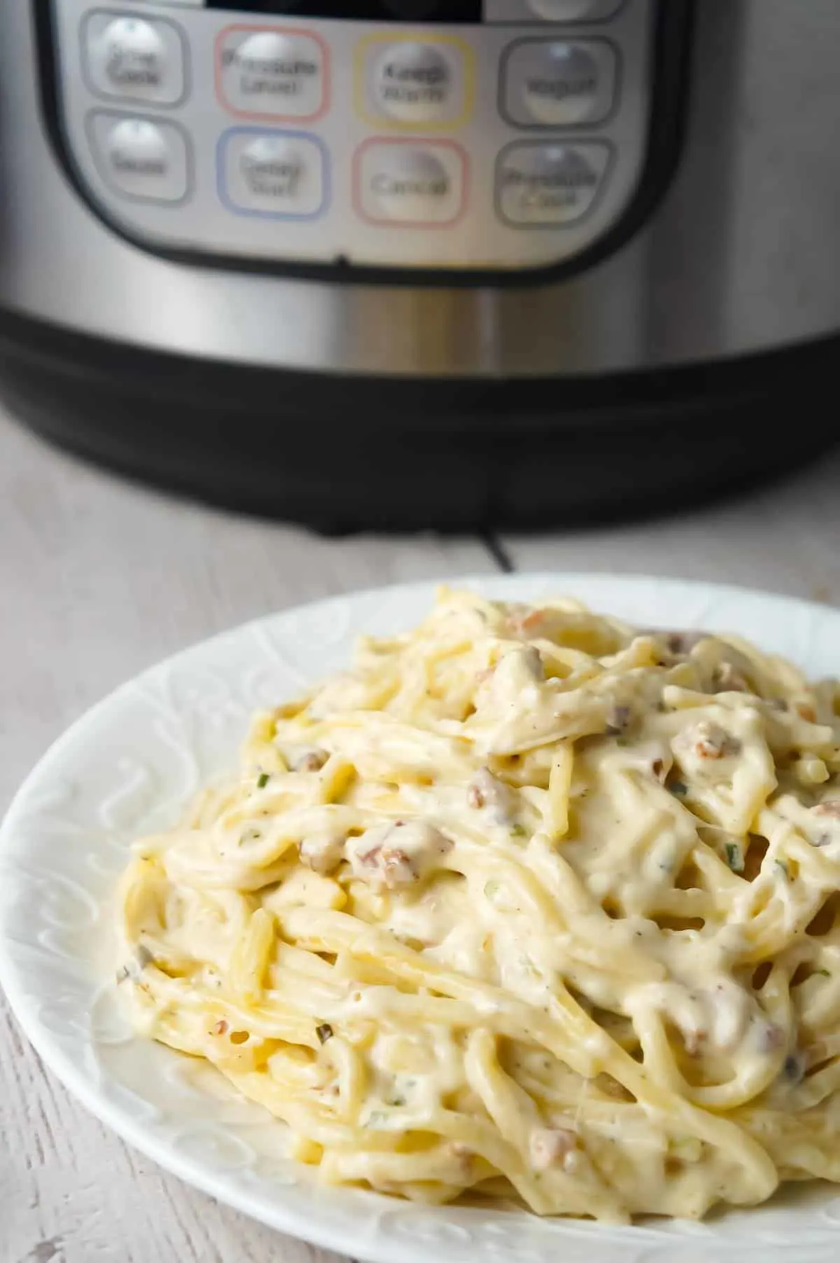 Instant Pot Bacon Cream Cheese Spaghetti is an easy pasta recipe made with heavy cream, chive and onion cream cheese, cream of bacon soup, shredded cheese and crumbled bacon.