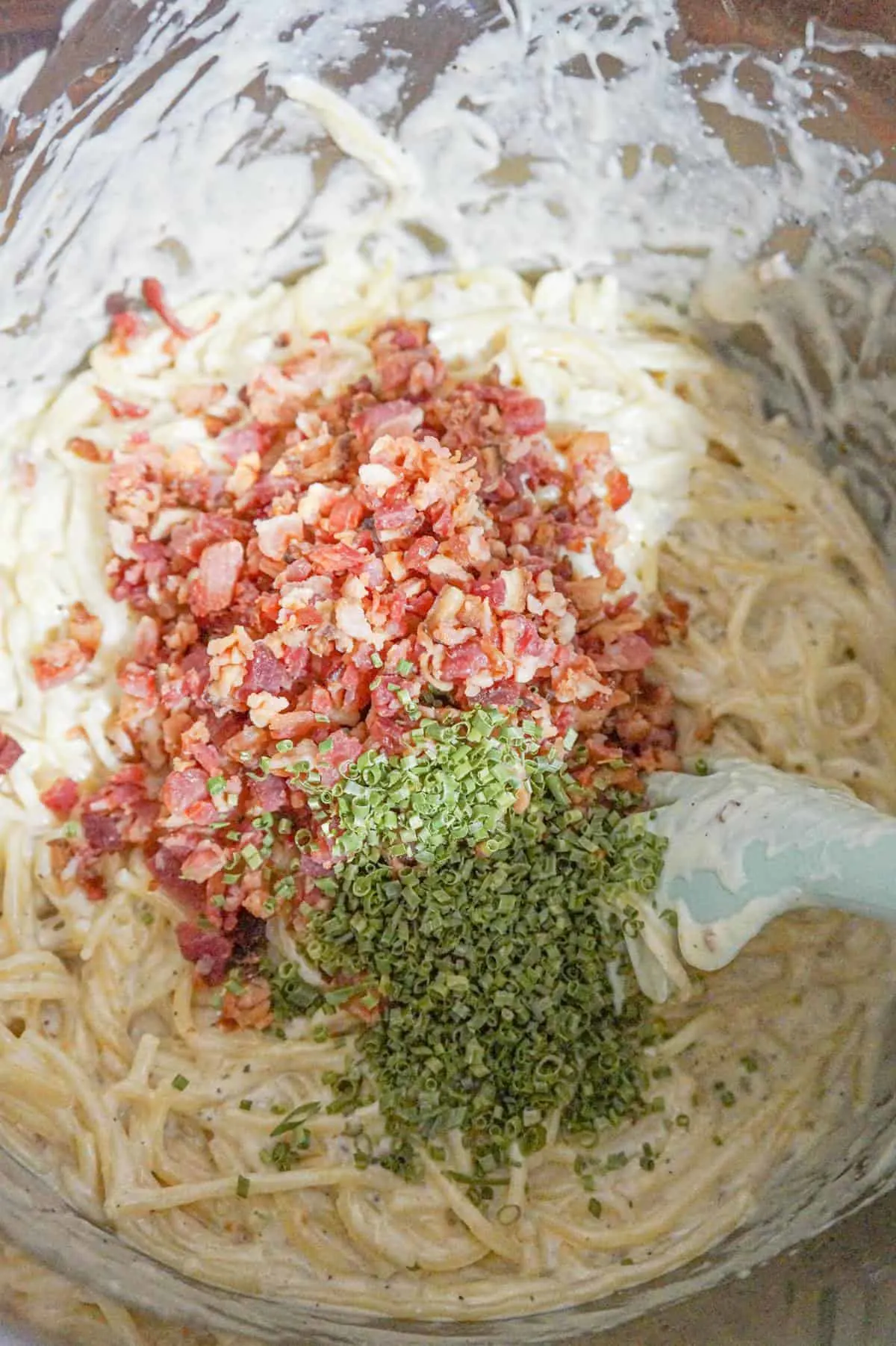 chopped chives and crumbled bacon on top of creamy spaghetti in an Instant Pot