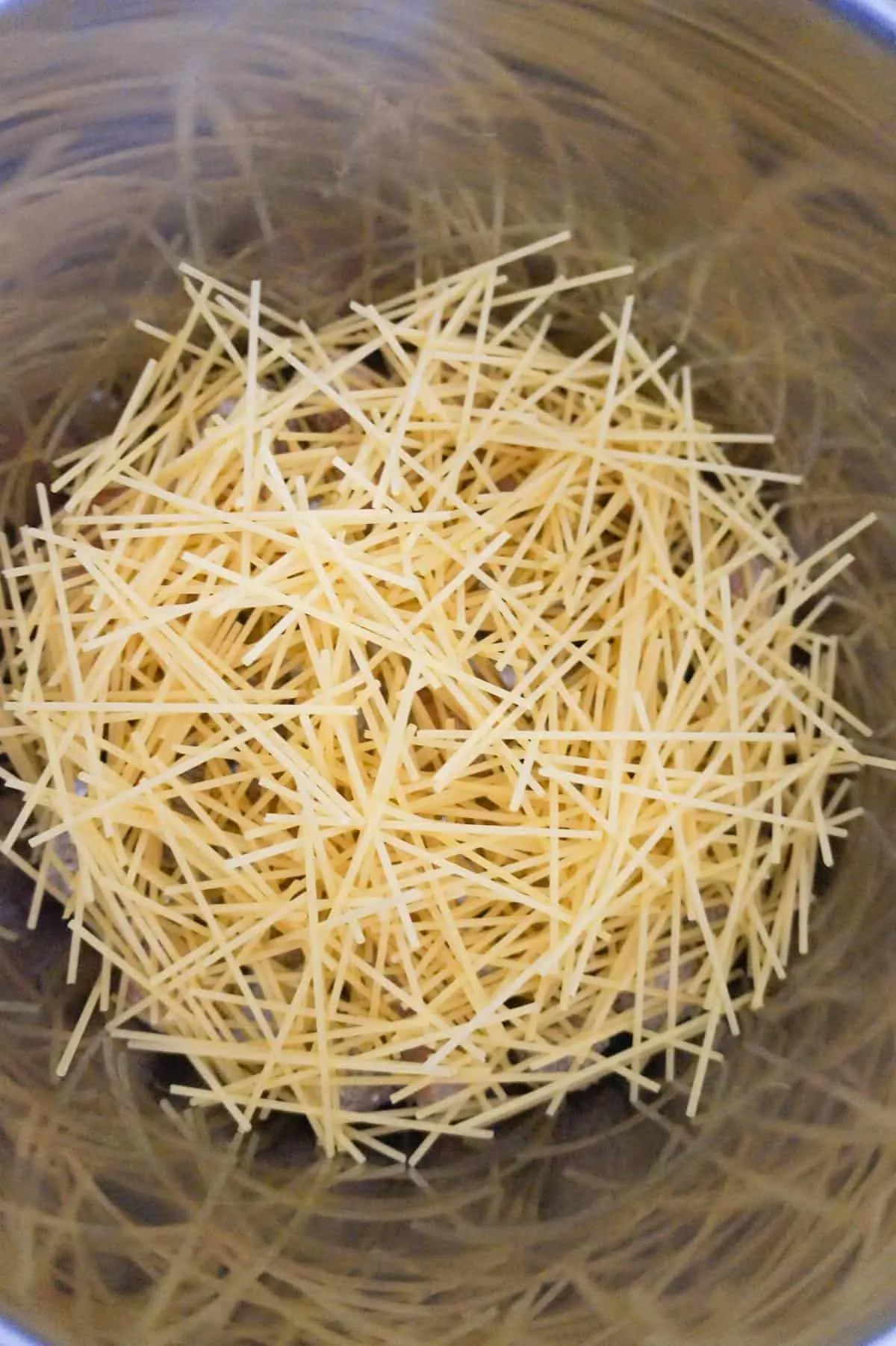 uncooked spaghetti noodles in an Instant Pot at all different angles
