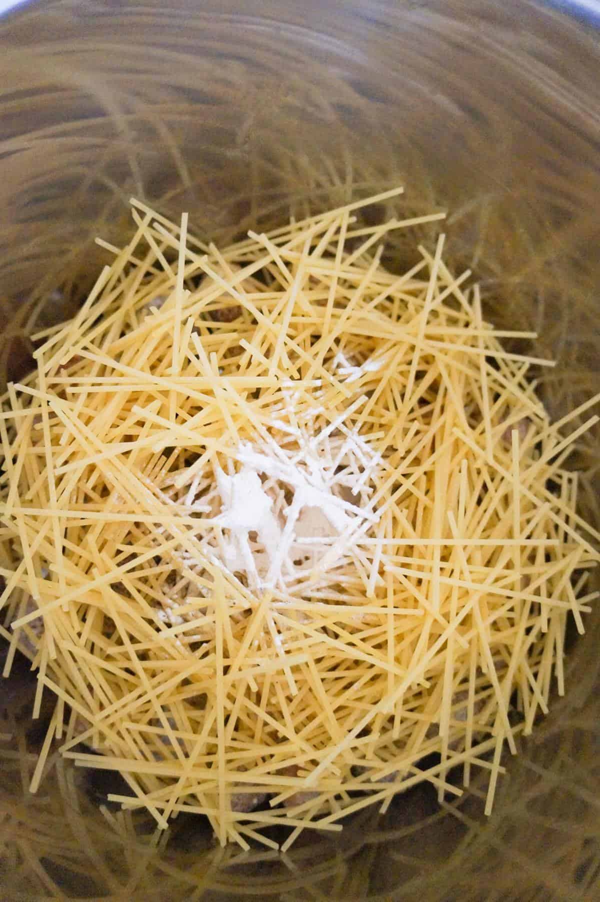 spices on top of uncooked spaghetti noodles in an Instant Pot