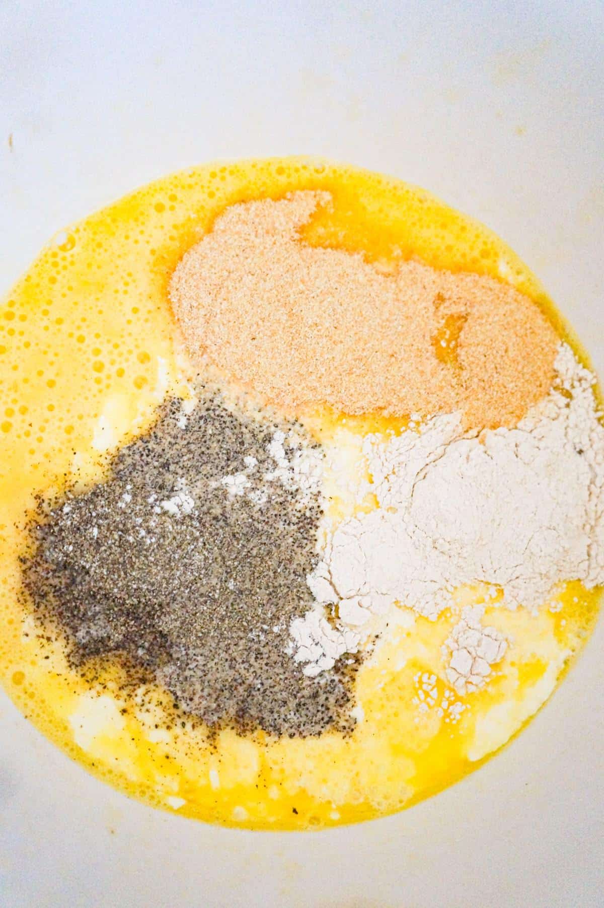 spices on top of beaten egg mixture in a mixing bowl