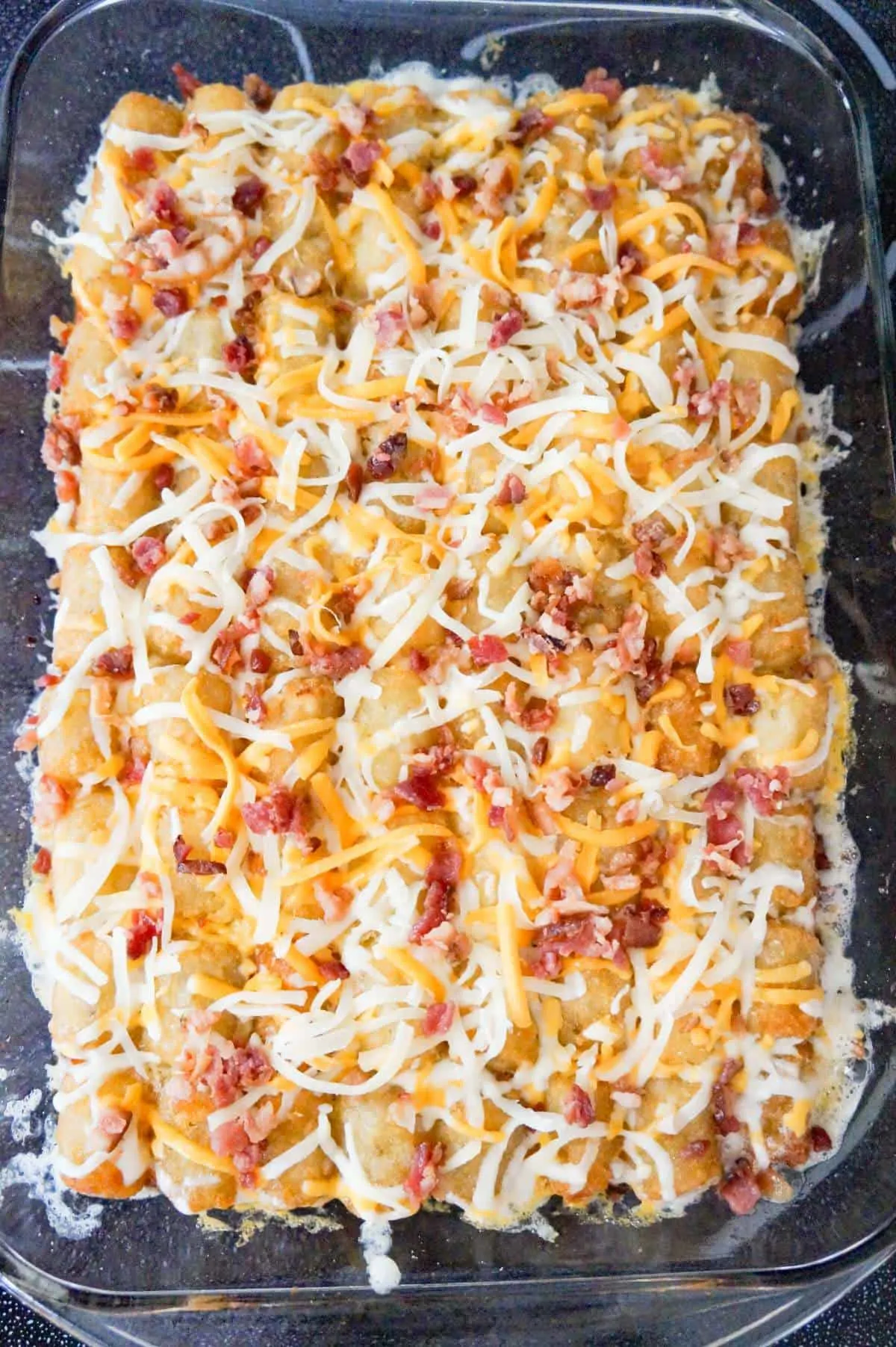 crumbled bacon and shredded cheese on top of tater tot casserole