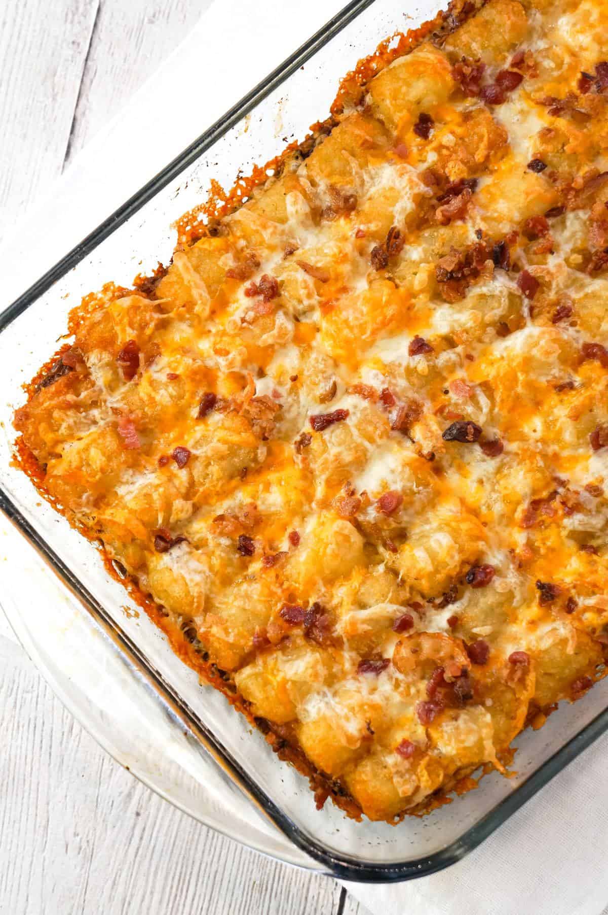 Tater Tot Breakfast Casserole is a hearty casserole recipe loaded with pork sausage meat, diced onion, chopped ham, crumbled bacon, eggs, shredded cheese and topped with tater tots.