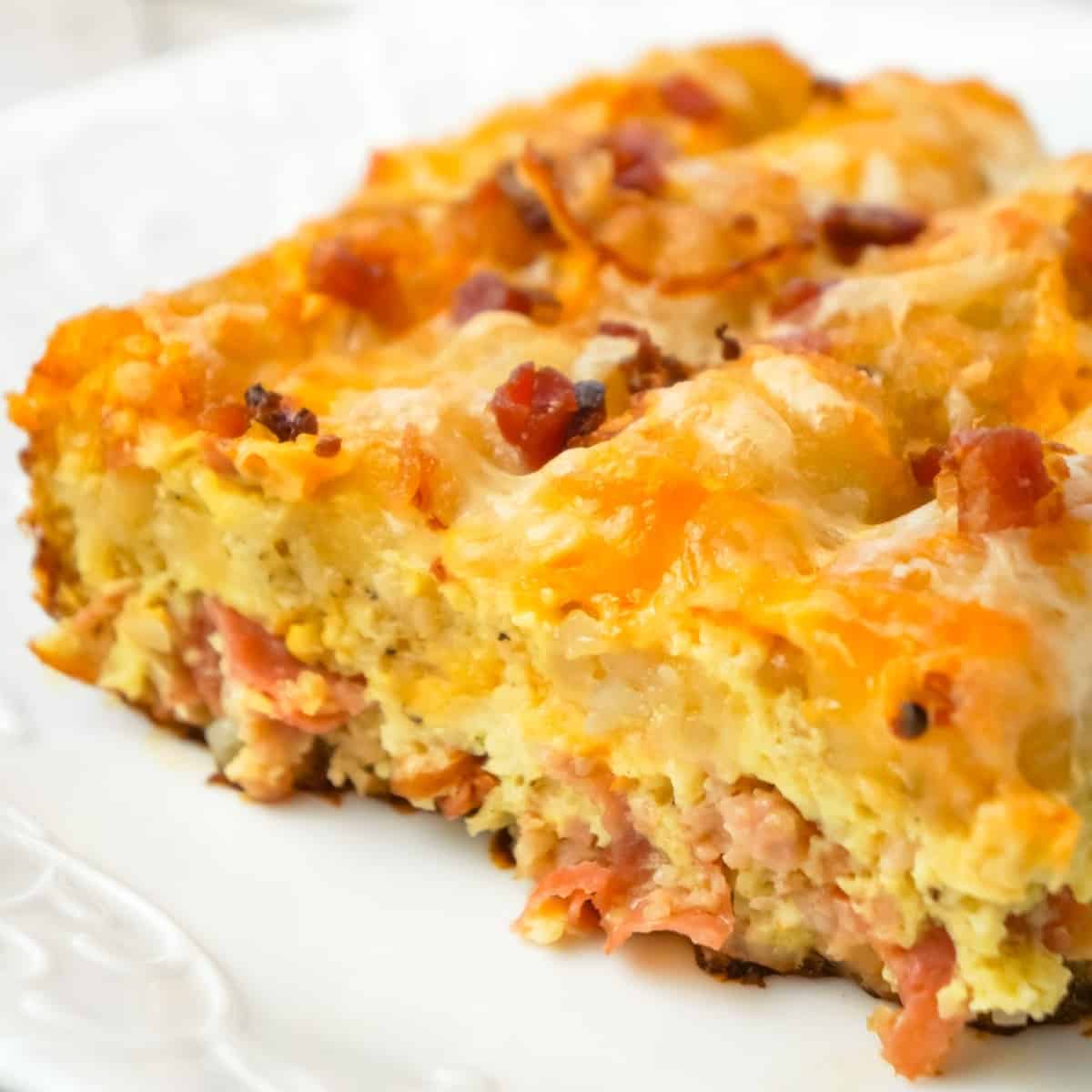 Tater Tot Breakfast Casserole is a hearty casserole recipe loaded with pork sausage meat, diced onion, chopped ham, crumbled bacon, eggs, shredded cheese and topped with tater tots.