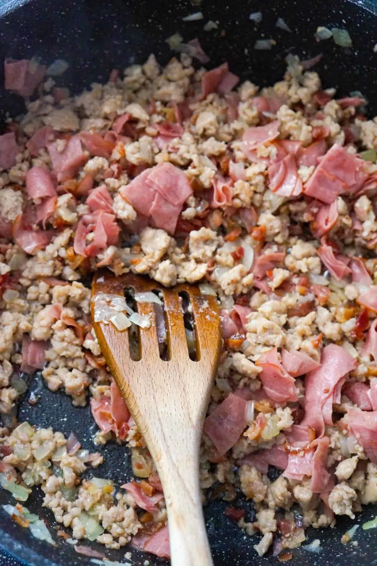 ground sausage meat, chopped ham and crumbled bacon in a saute pan