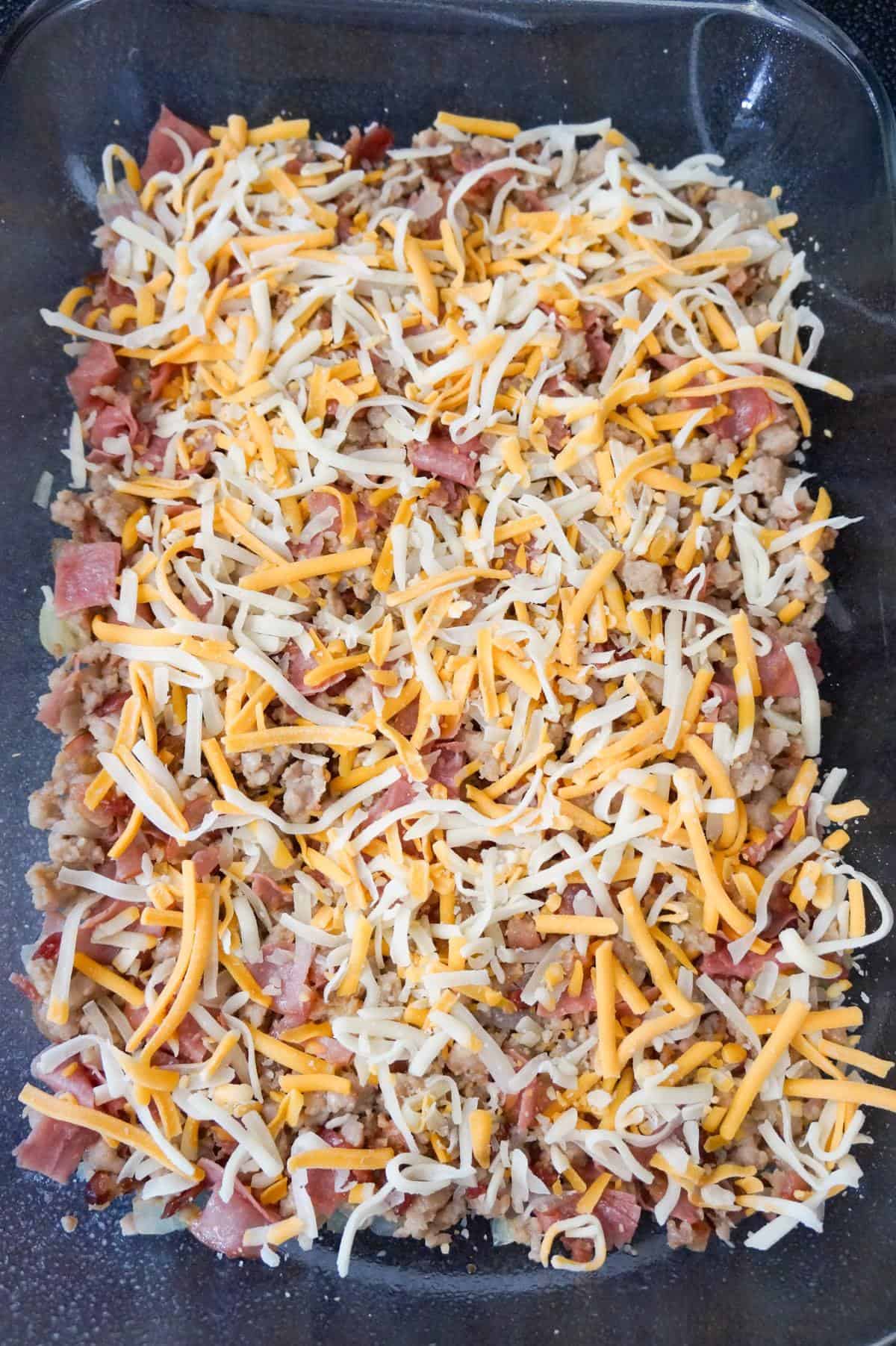 shredded cheese on top of meat mixture in a baking dish