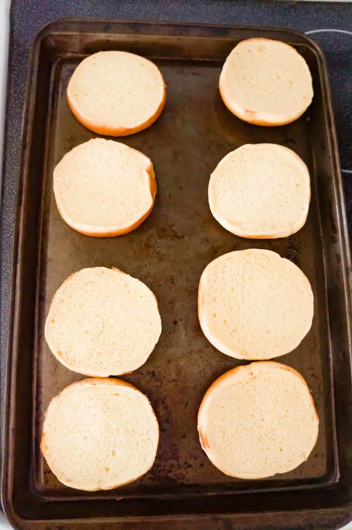 hamburger buns in a single layer on a baking pan