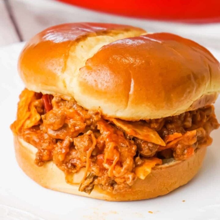 Beef Nacho Sloppy Joes is an easy ground beef dinner recipe loaded with taco seasoning, salsa, chili sauce, crumbled nacho chips and shredded cheese.