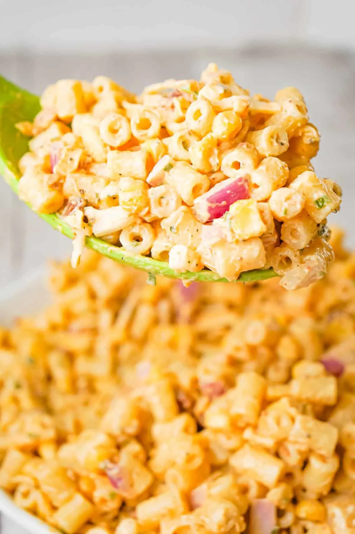 Cajun Macaroni Salad is a cold side dish recipe loaded with canned corn, crumbled bacon, diced red onions, shredded cheese and tossed in mayo and Cajun seasoning.