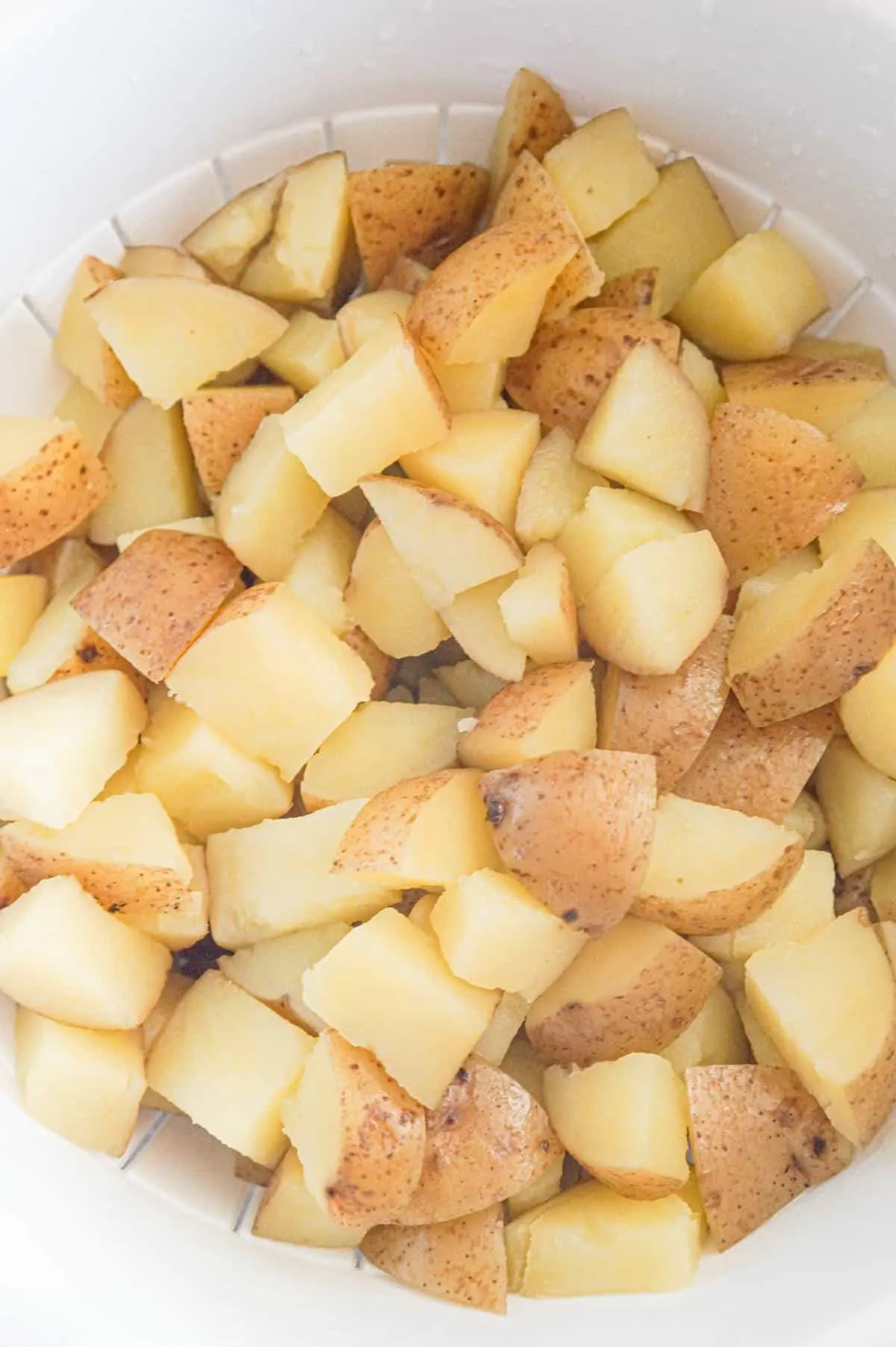 cooked diced potatoes in a colander