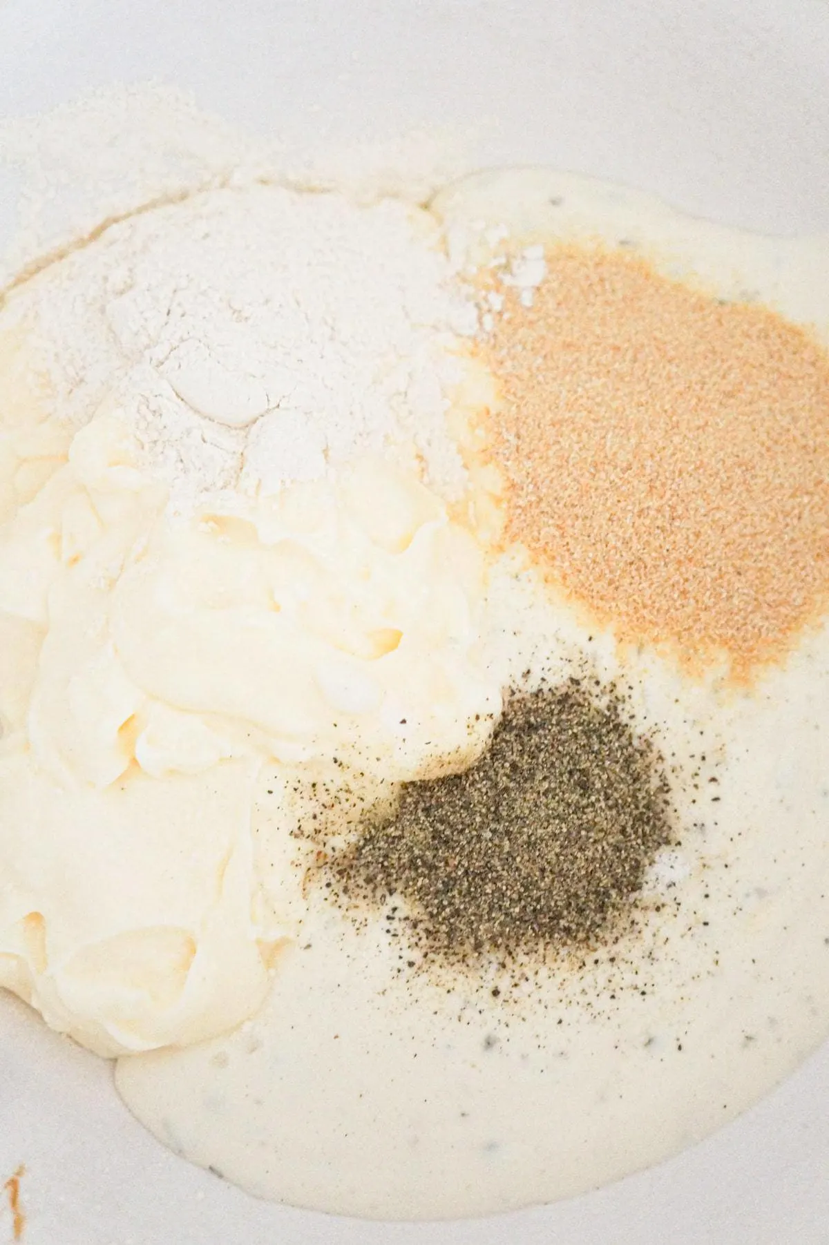 spices on top of ranch dressing and mayo in a mixing bowl