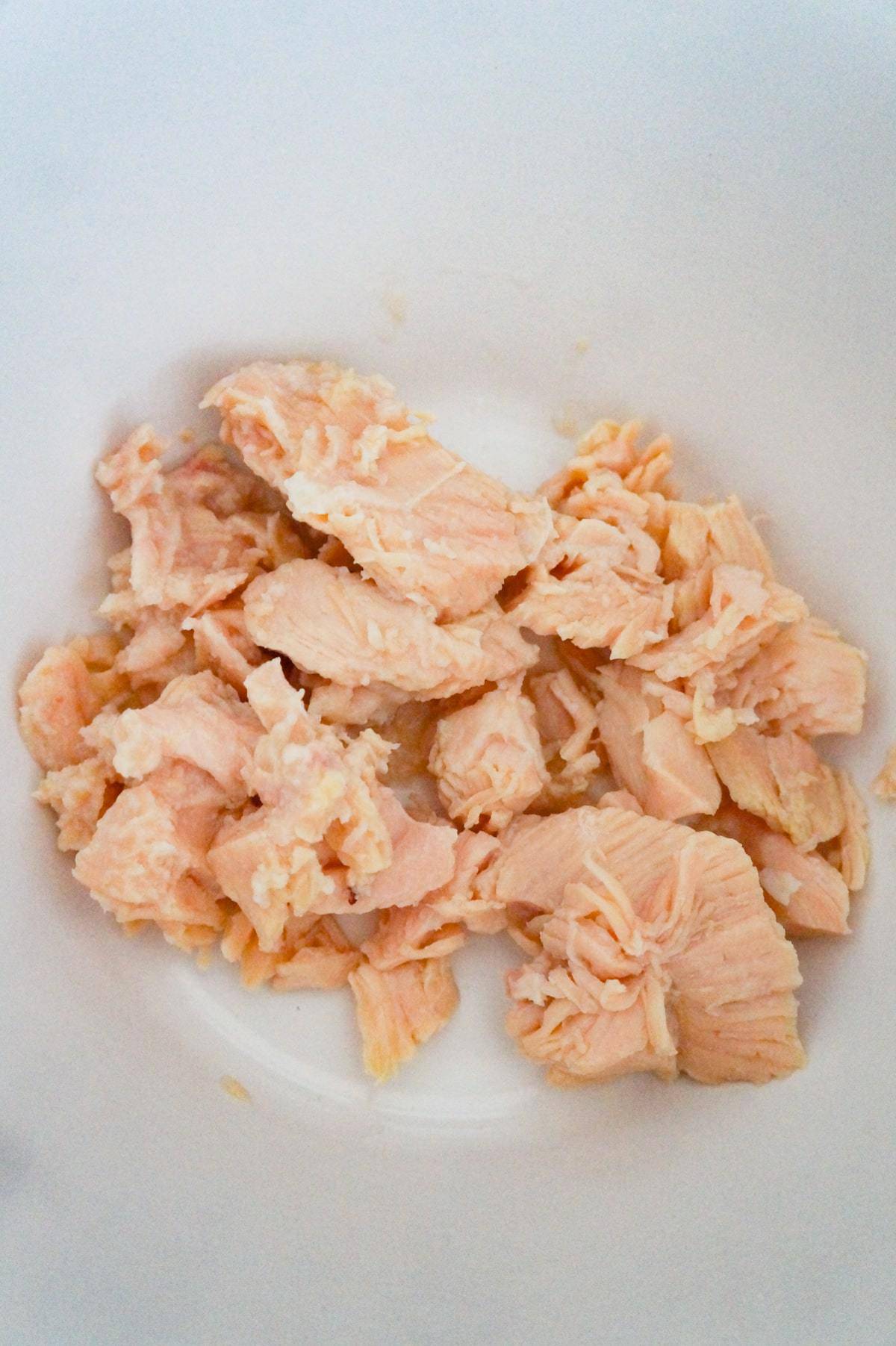 chunks of canned chicken in a mixing bowl