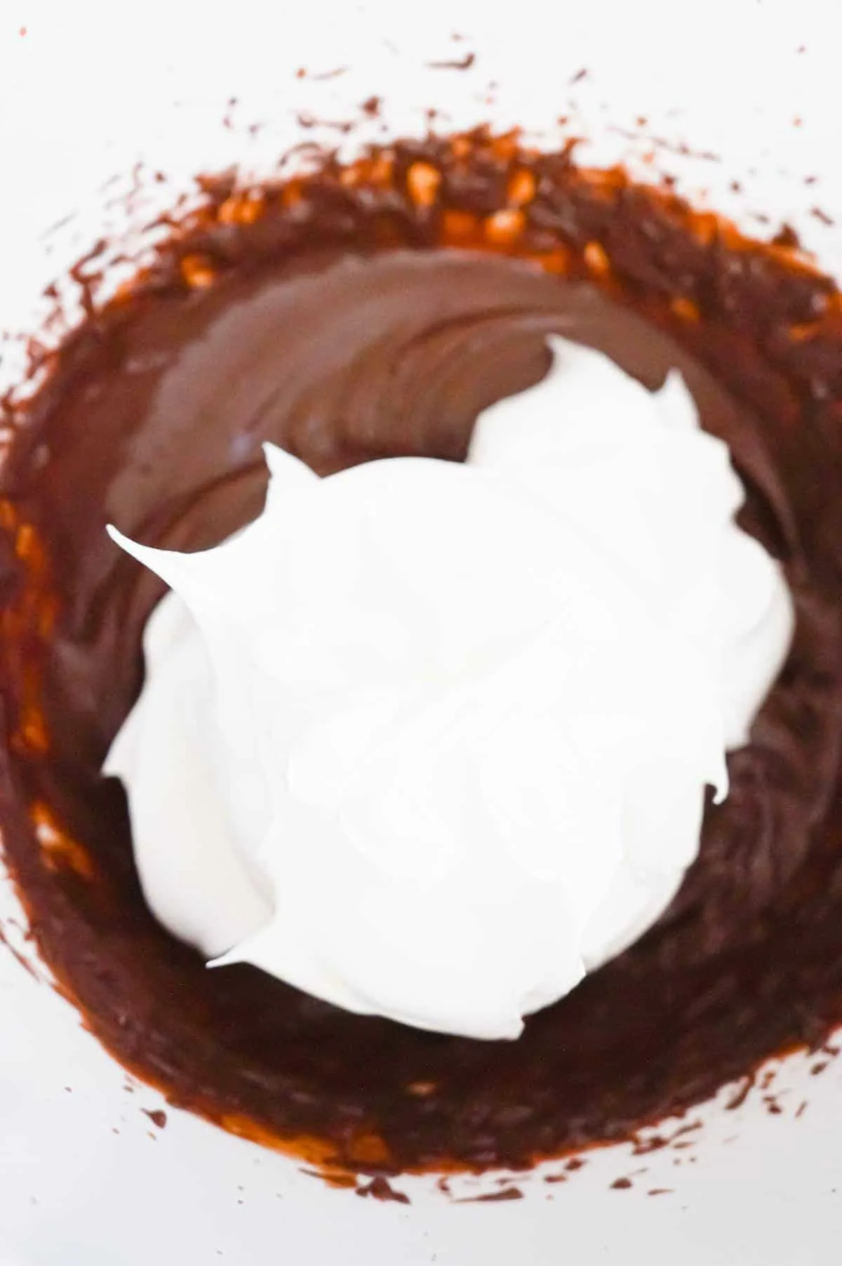 cool whip on top of chocolate pudding in a mixing bowl