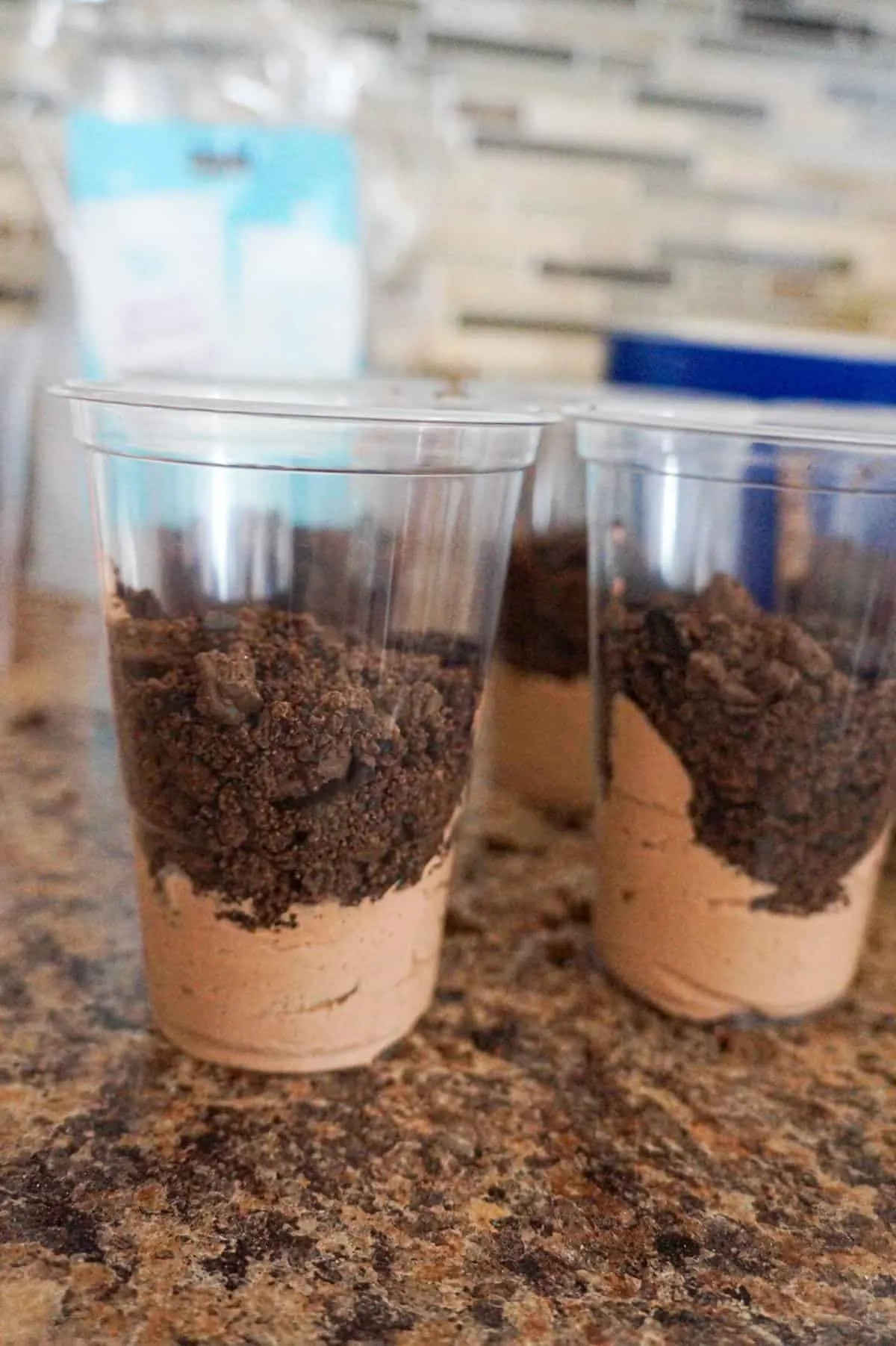 cookie crumble on top of pudding mixture in clear plastic cups