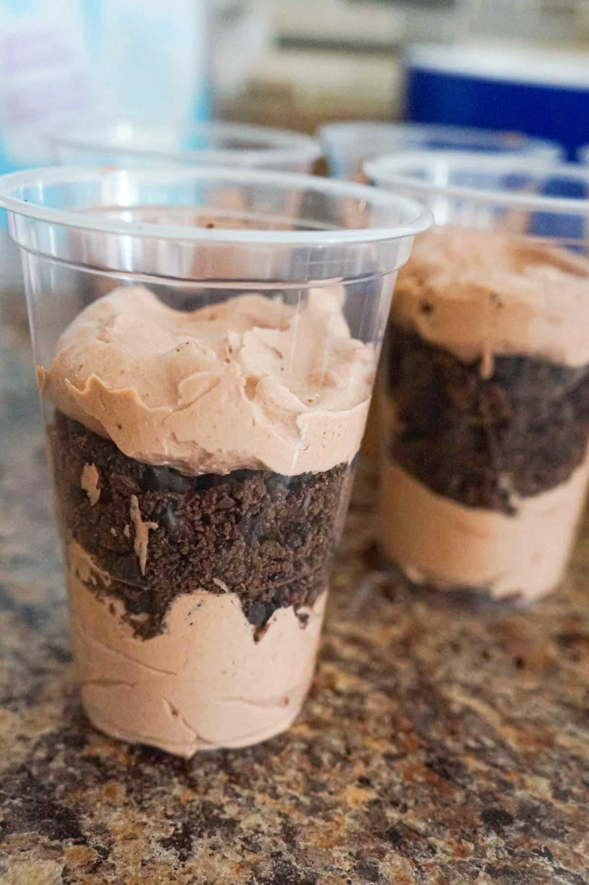 layers of cool whip and chocolate pudding mixture and crumbled cookies in cups