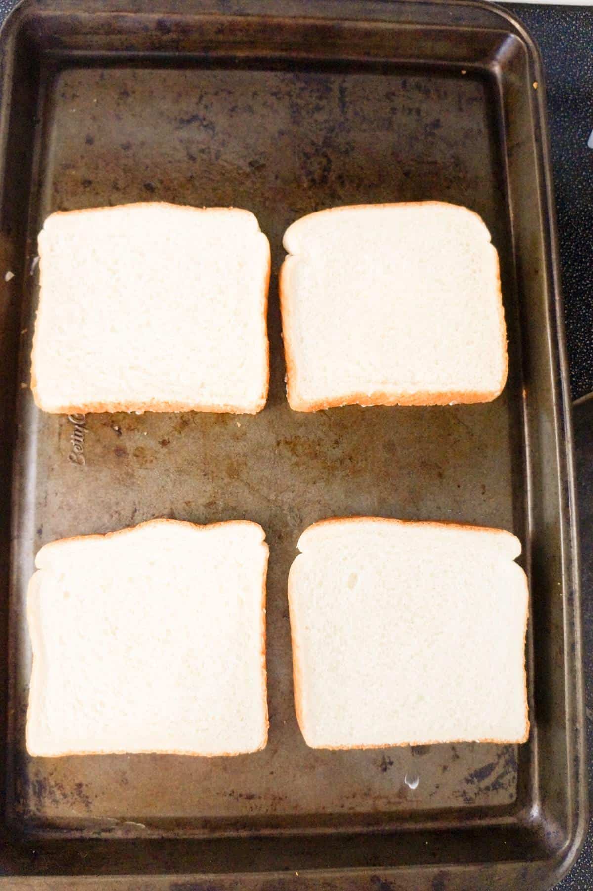 four slices of bread on a baking sheet