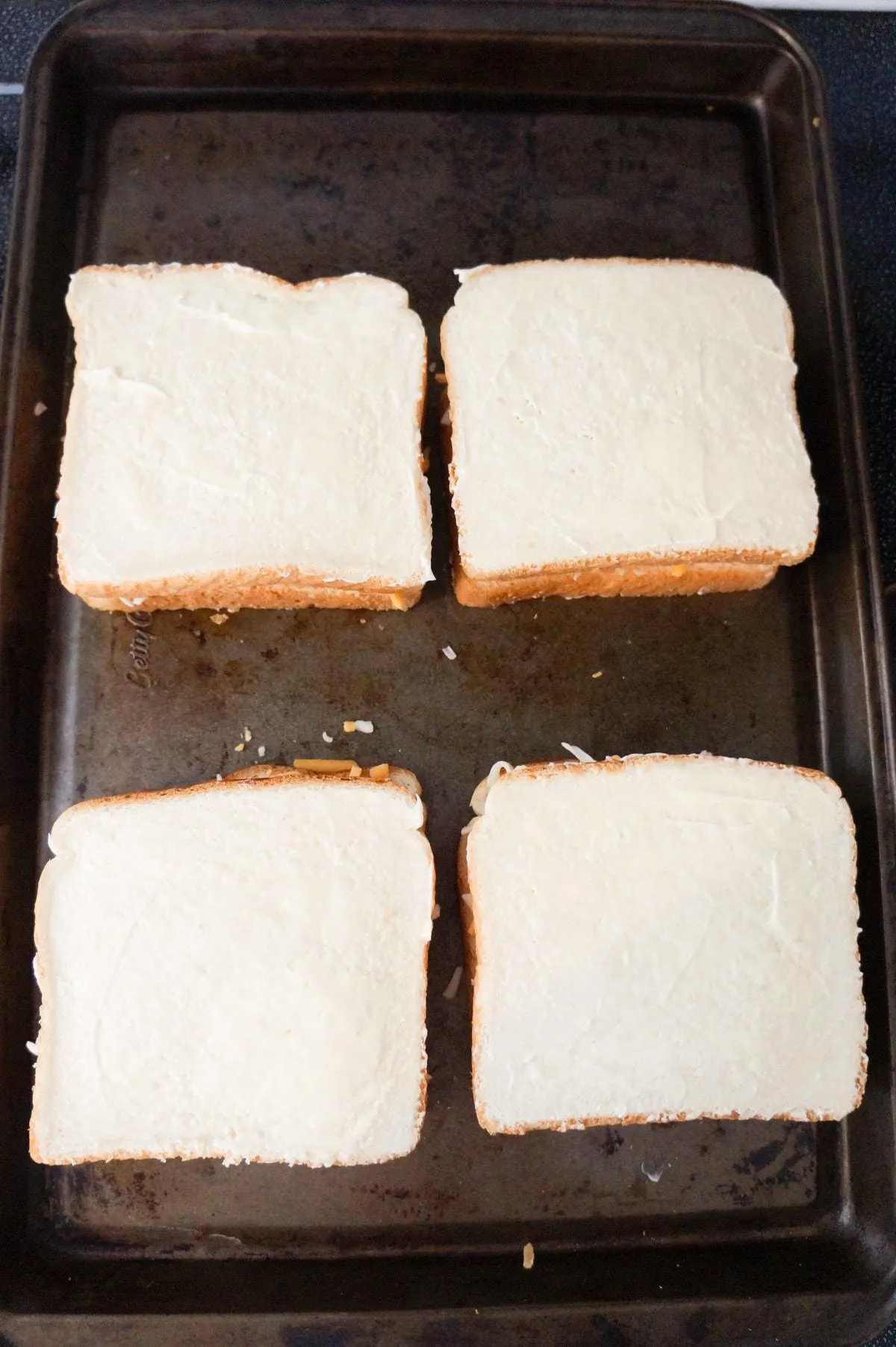 uncooked grilled cheese sandwiches on a baking sheet