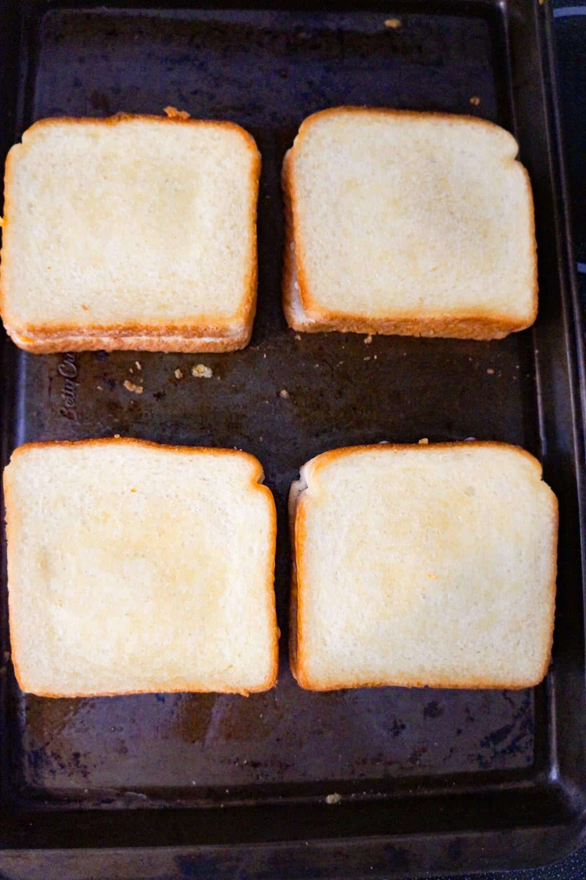 four sandwiches on a baking sheet