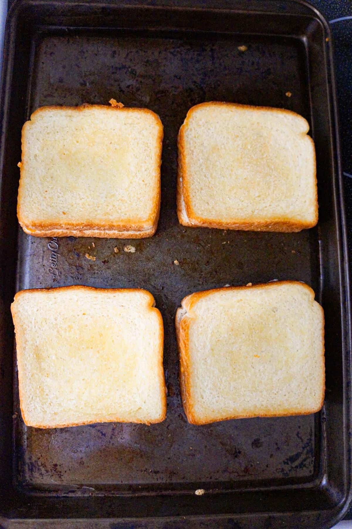 grilled cheese sandwiches on a baking sheet