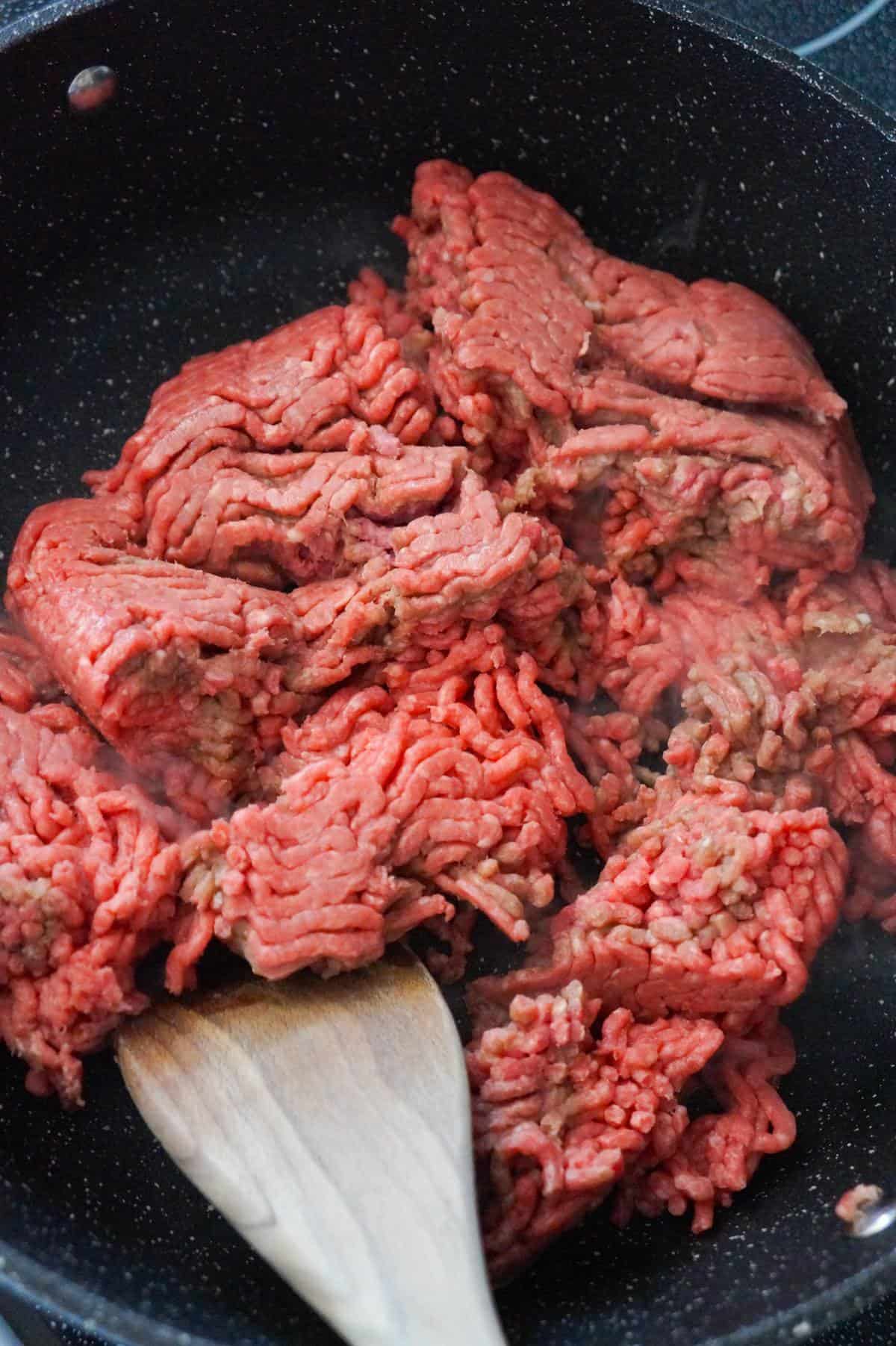 raw ground beef in a large saute pan