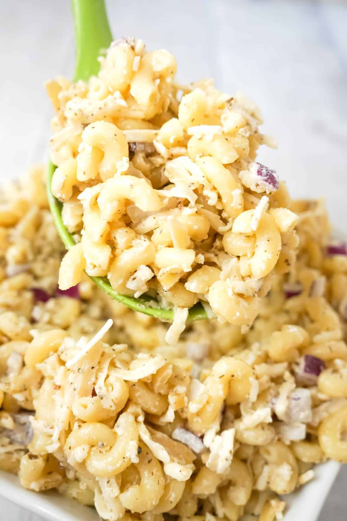 Basil Pesto Pasta Salad is an easy cold side dish recipe loaded with diced red onions, slivered almonds, mozzarella cheese and Parmesan cheese all tossed in mayo and basil pesto.