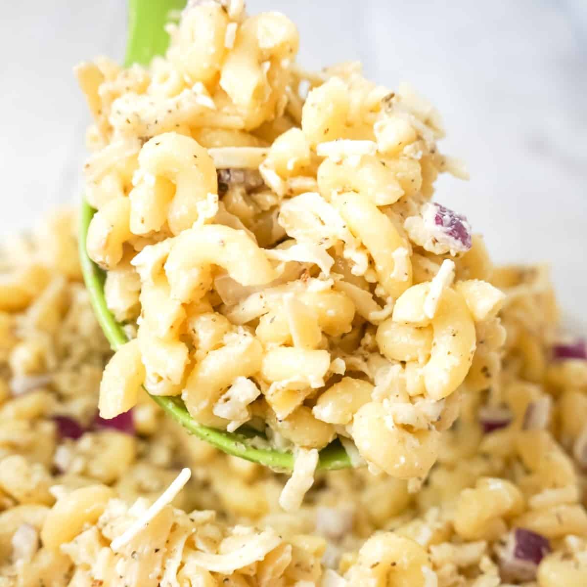 Basil Pesto Pasta Salad is an easy cold side dish recipe loaded with diced red onions, slivered almonds, mozzarella cheese and Parmesan cheese all tossed in mayo and basil pesto.