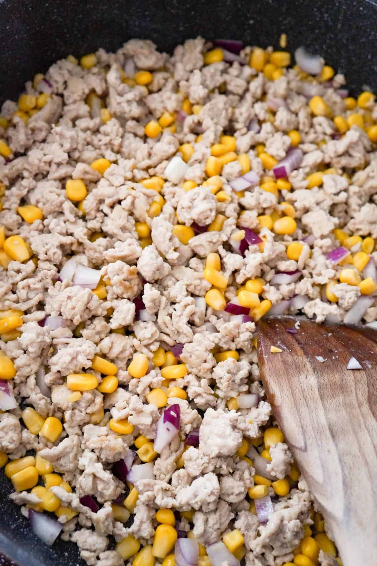 ground chicken, corn and diced red onions in a saute pan