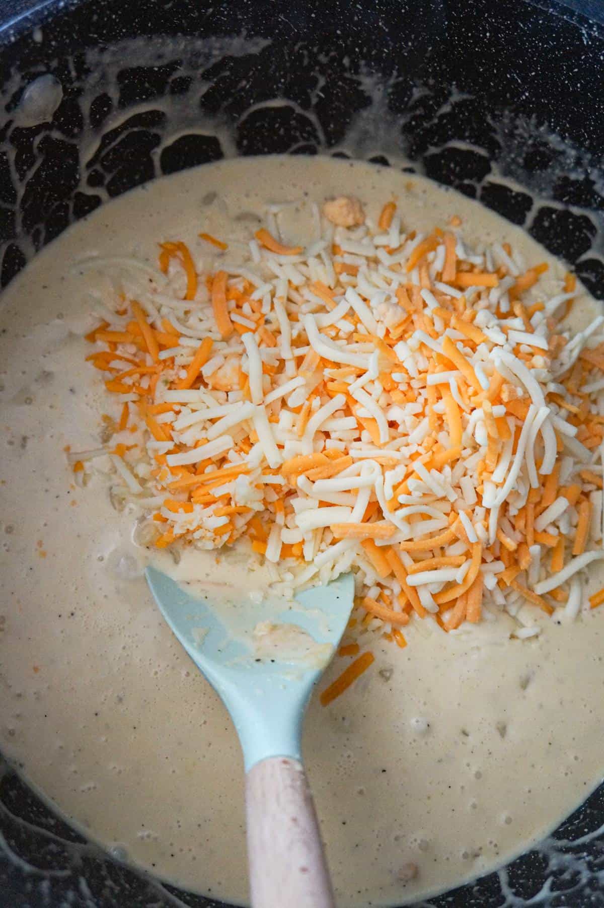 shredded mozzarella and cheddar cheese in a large pot