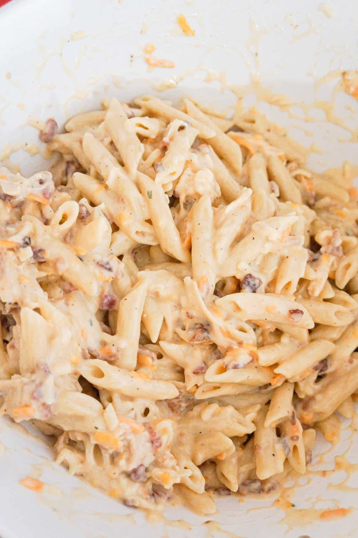 creamy chicken penne in a mixing bowl