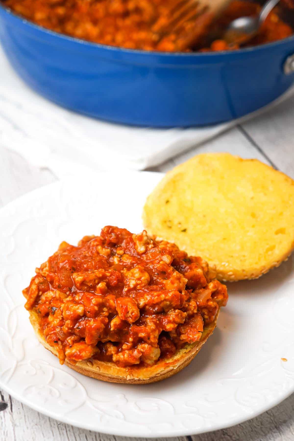 Chicken Parmesan Sloppy Joes are an easy weeknight dinner recipe made with ground chicken tossed in marinara, basil pesto and Parmesan cheese topped with shredded mozzarella and served on a toasted garlic butter brioche bun.