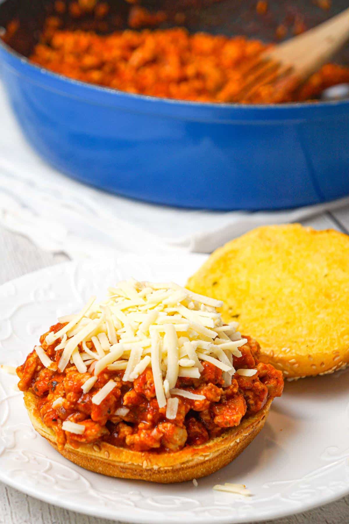 Chicken Parmesan Sloppy Joes are an easy weeknight dinner recipe made with ground chicken tossed in marinara, basil pesto and Parmesan cheese topped with shredded mozzarella and served on a toasted garlic butter brioche bun.