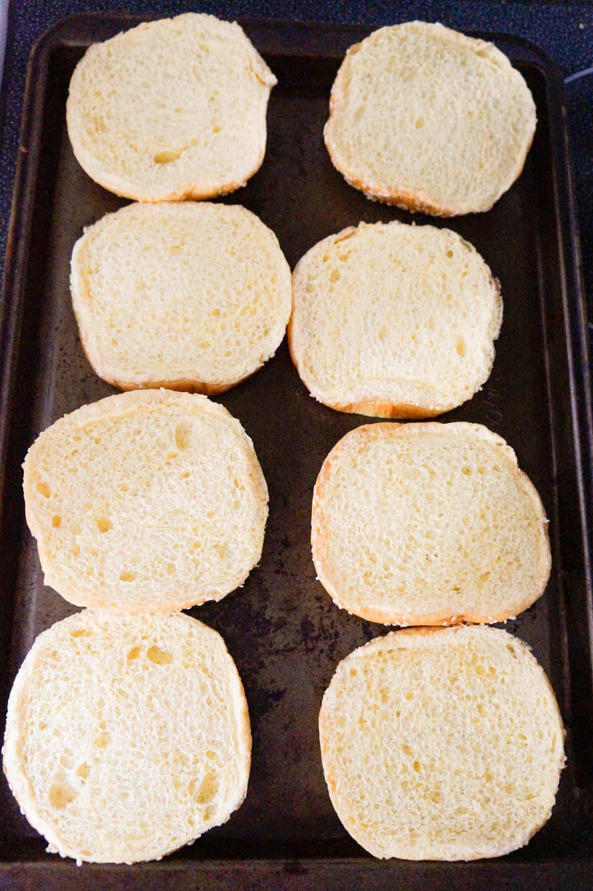 brioche buns in a single layer on a baking sheet