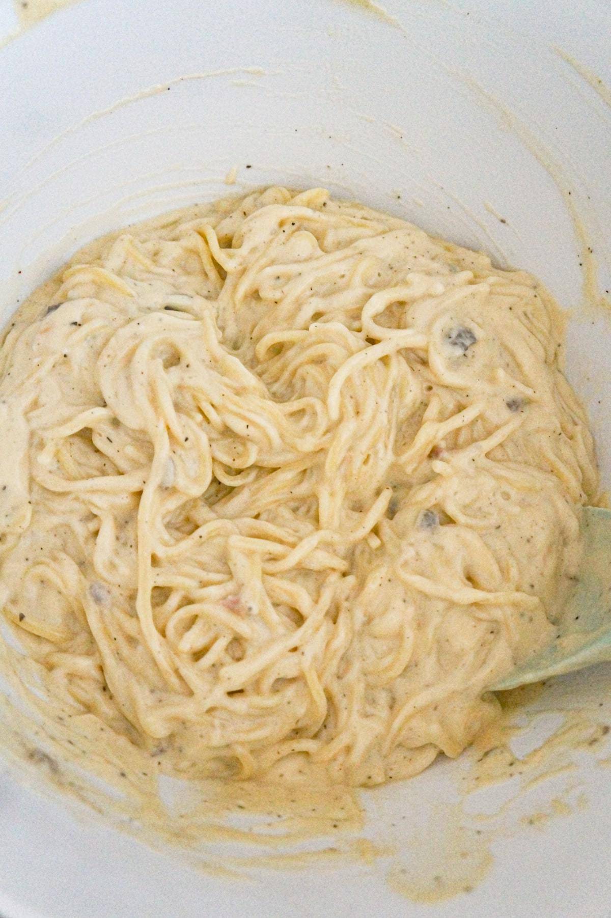 creamy spaghetti in a mixing bowl