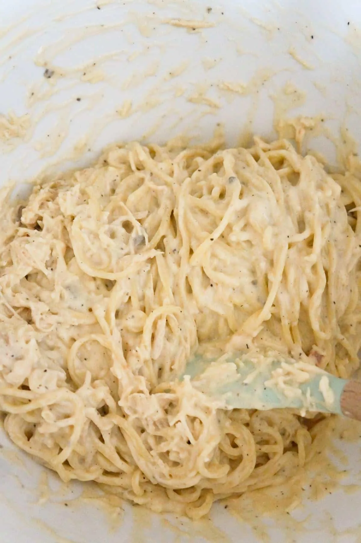 creamy chicken spaghetti in a mixing bowl