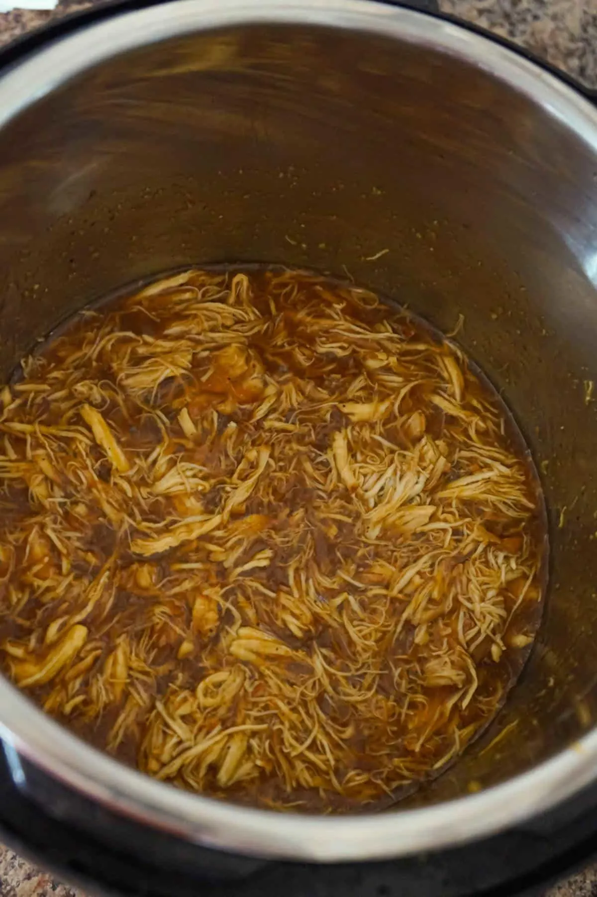 shredded chicken in honey garlic sauce in an Instant Pot
