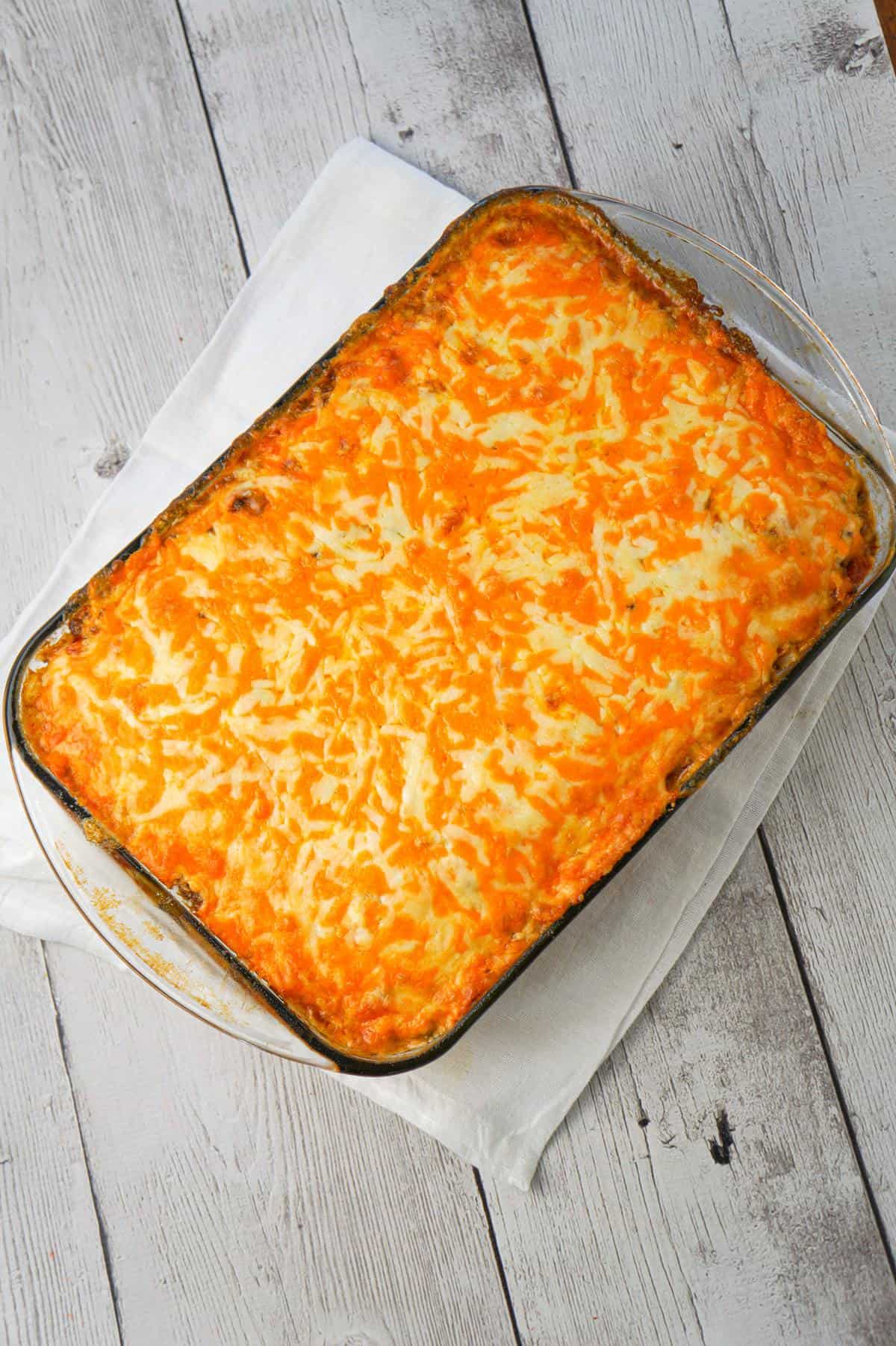 John Wayne Casserole is an easy ground beef casserole recipe with a biscuit base and loaded with diced tomatoes, corn, taco seasoning, cream cheese, mozzarella and cheddar.