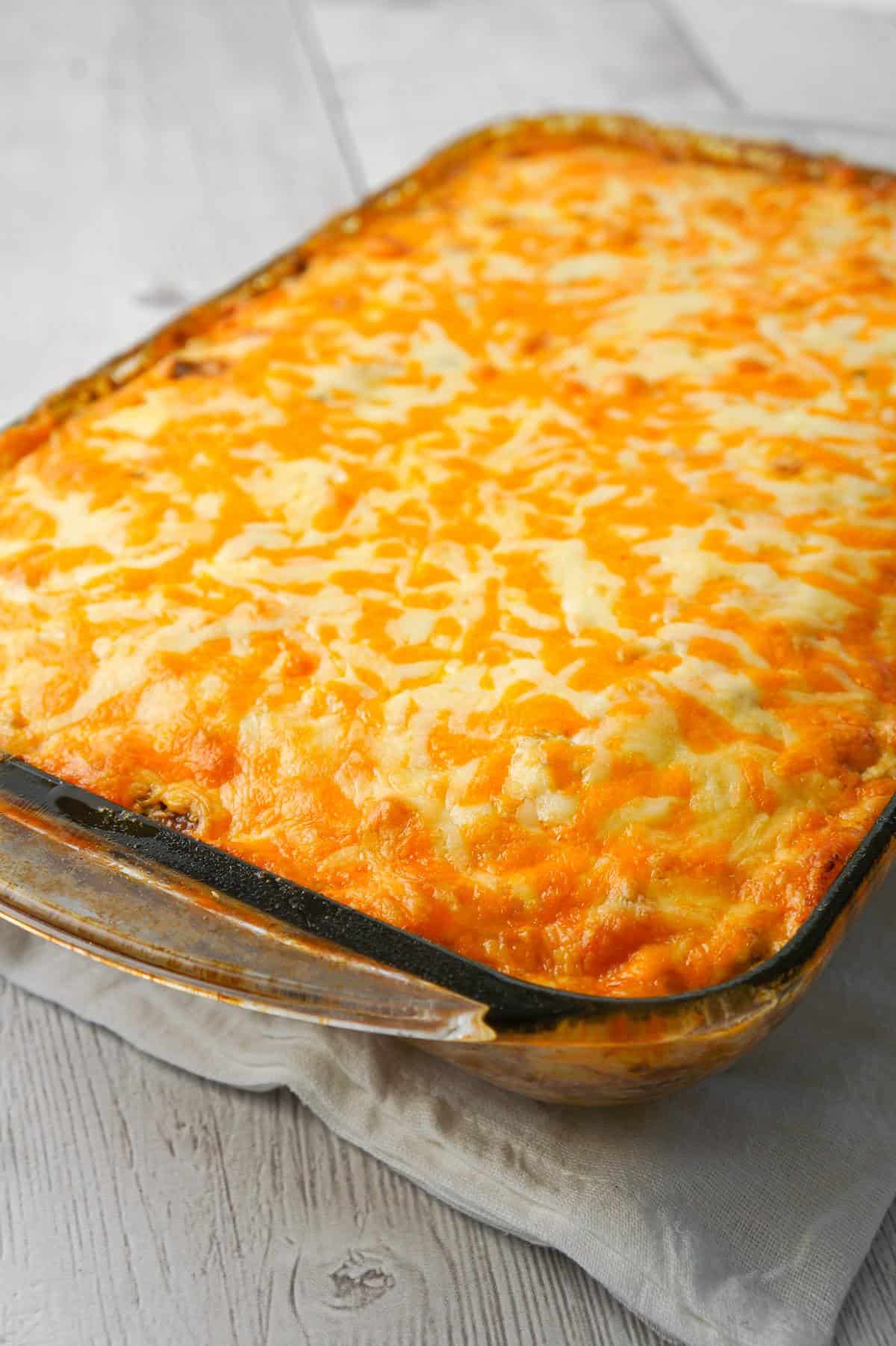 John Wayne Casserole is an easy ground beef casserole recipe with a biscuit base and loaded with diced tomatoes, corn, taco seasoning, cream cheese, mozzarella and cheddar.