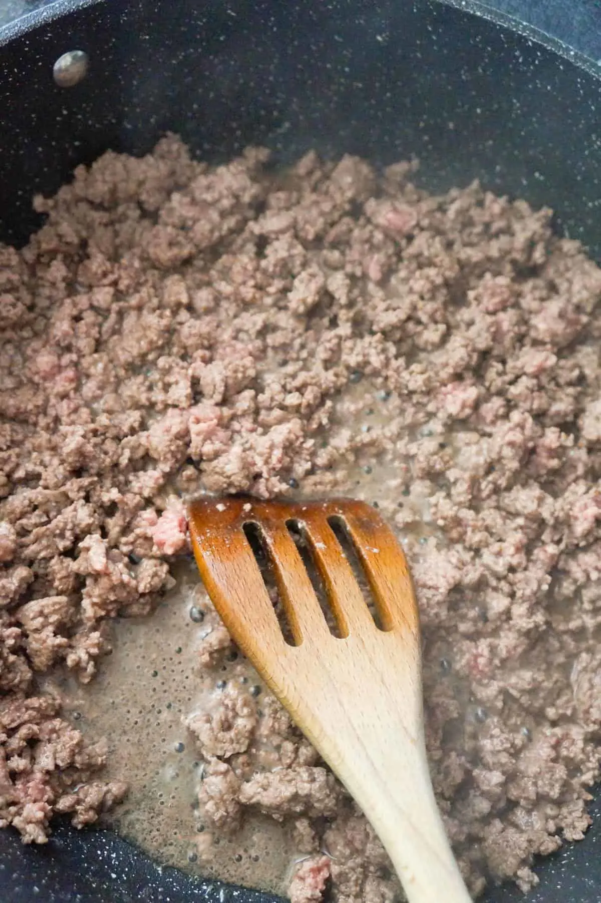 ground beef cooking in a saute pan