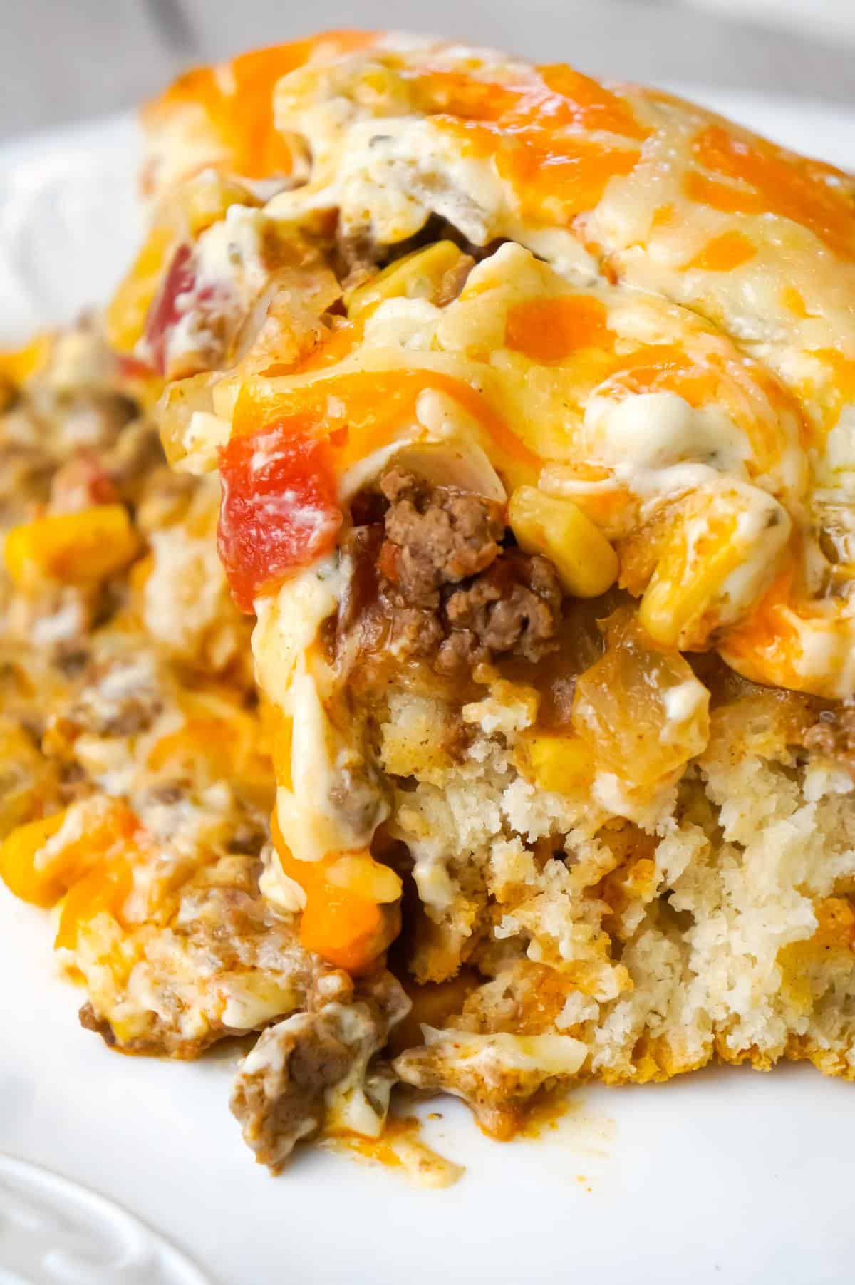 John Wayne Casserole is an easy ground beef casserole recipe with a biscuit base and loaded with diced tomatoes, corn, taco seasoning, cream cheese, mozzarella and cheddar.