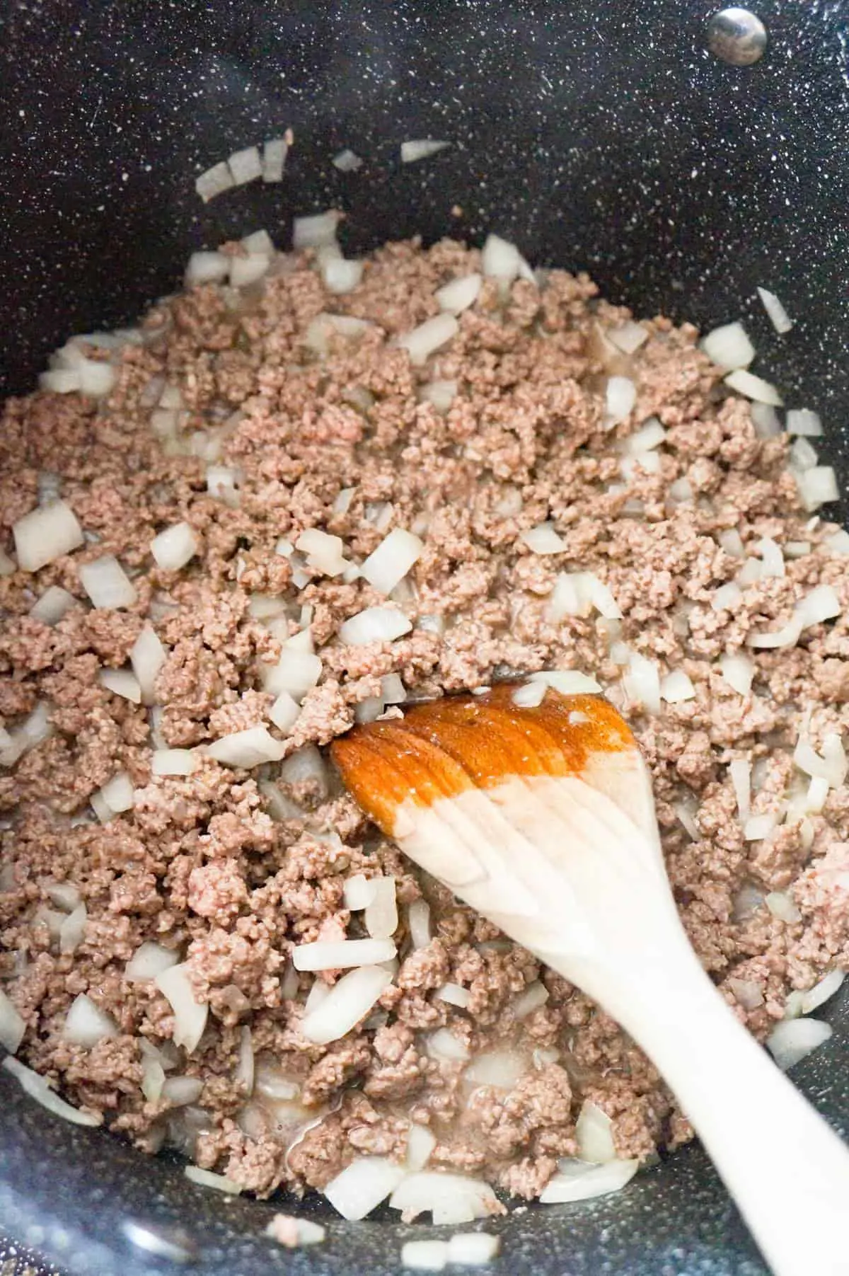 diced onions and ground beef cooking in a large pot